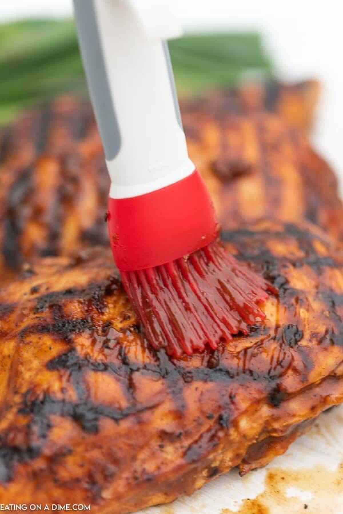 Grilled BBQ Chicken being brushed with sauce
