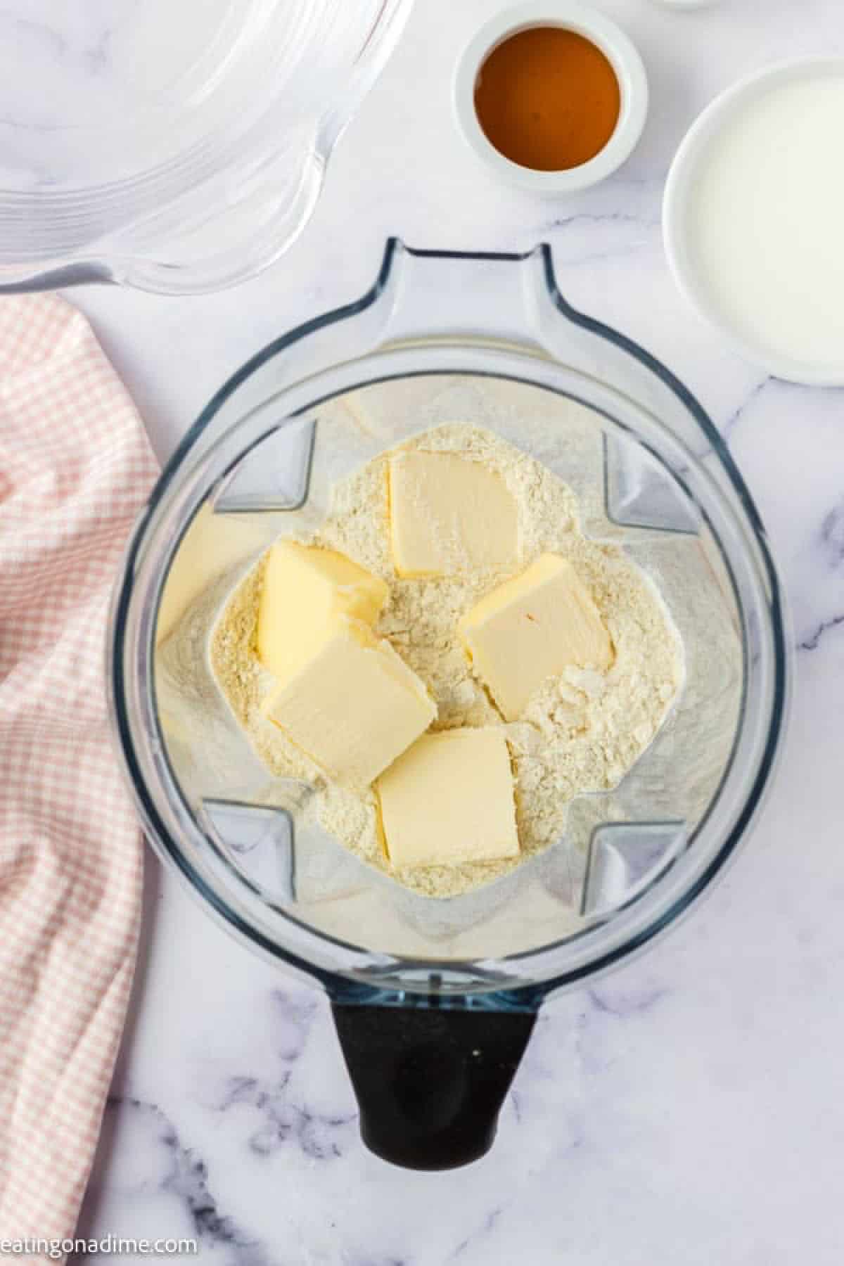 Flour in a food processor with slices of butter 