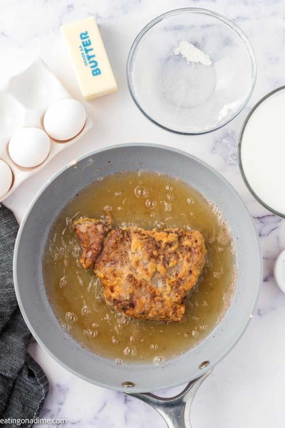 Frying chicken fried steak in a skillet with oil
