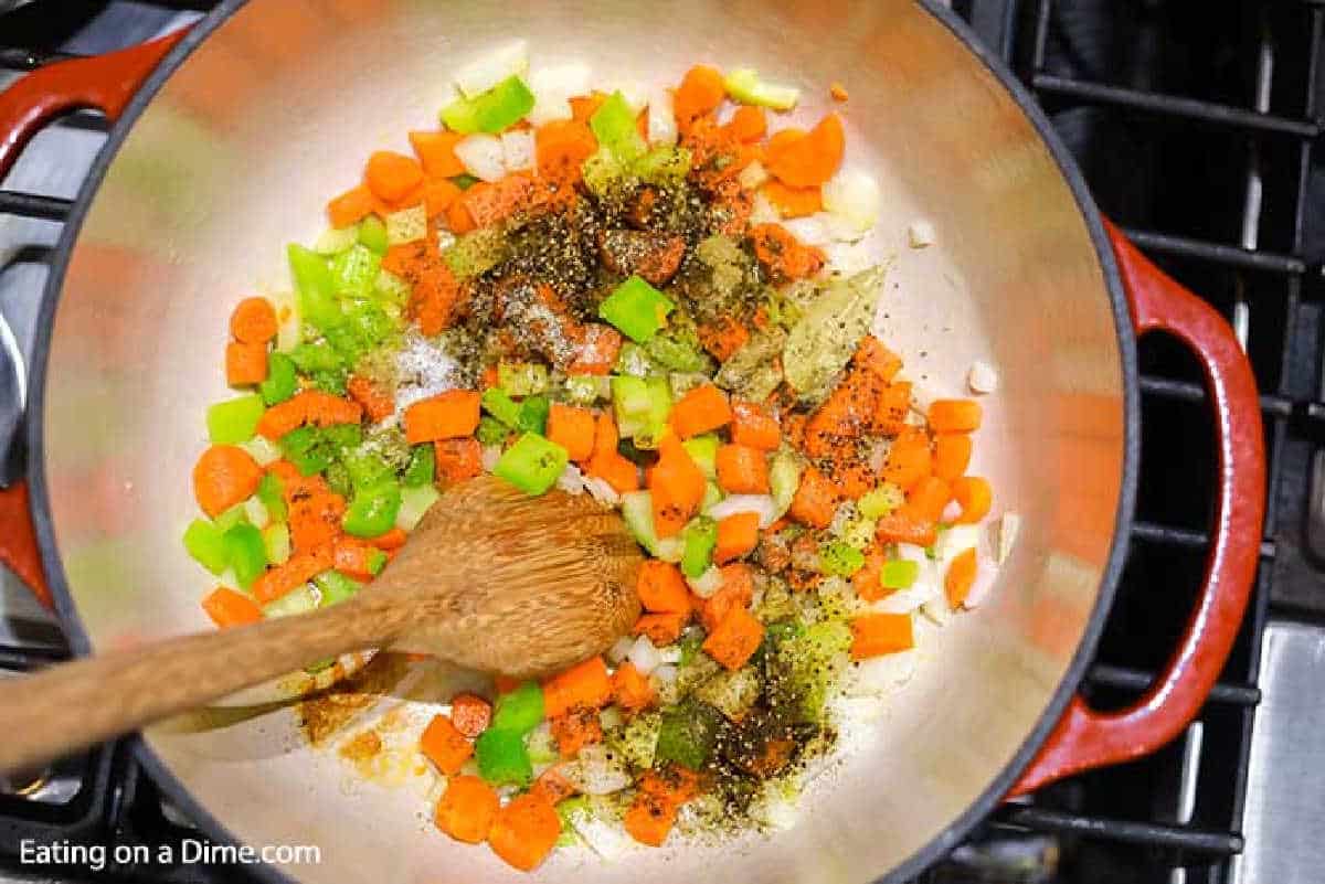 Adding in seasoning with the vegetables in the large pot