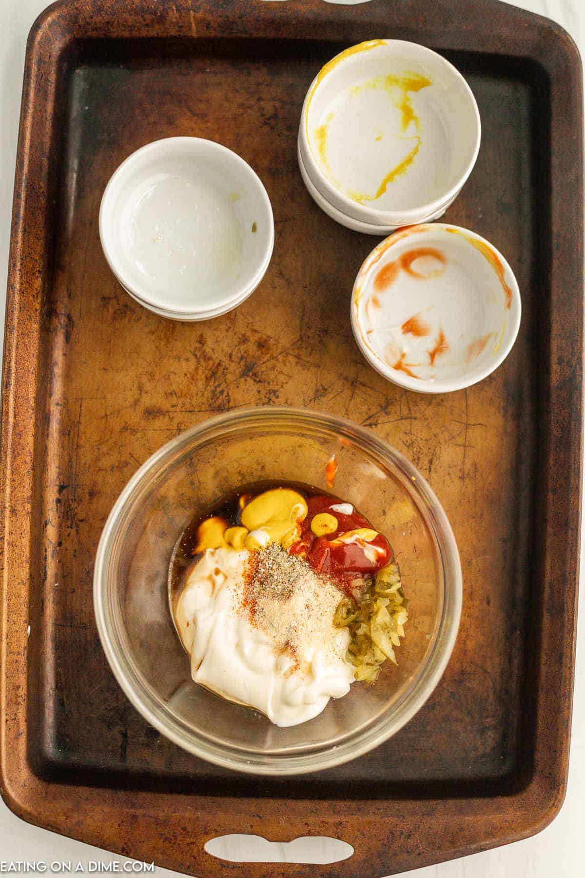 Adding the ingredient to a bowl with empty white bowls on the side