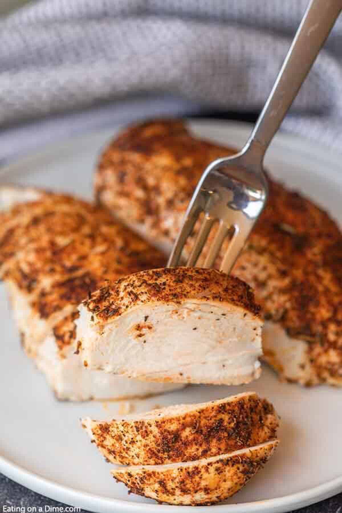 Oven Baked Chicken on a plate sliced with a piece on a fork