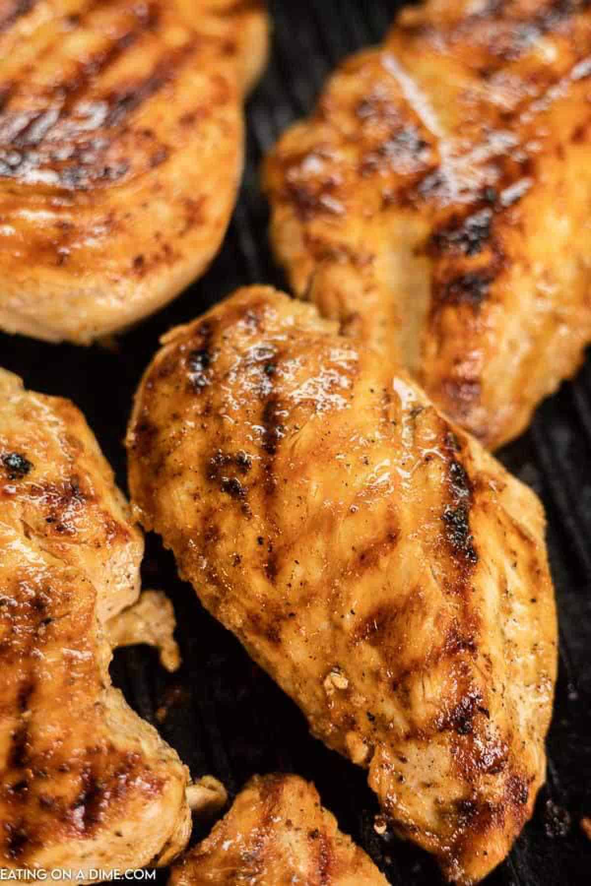 4 chicken breasts on a grill. 