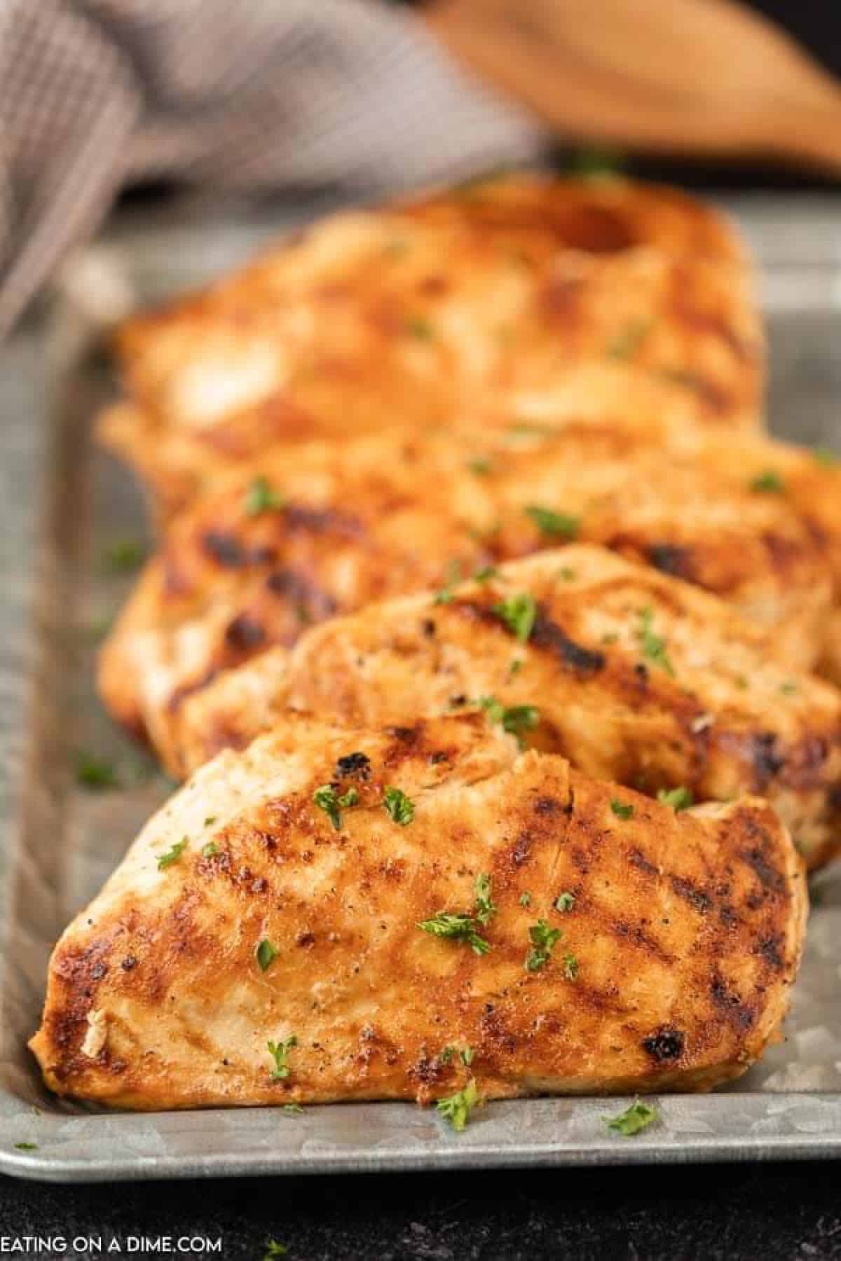 Grilled chicken breasts on a silver platter. 