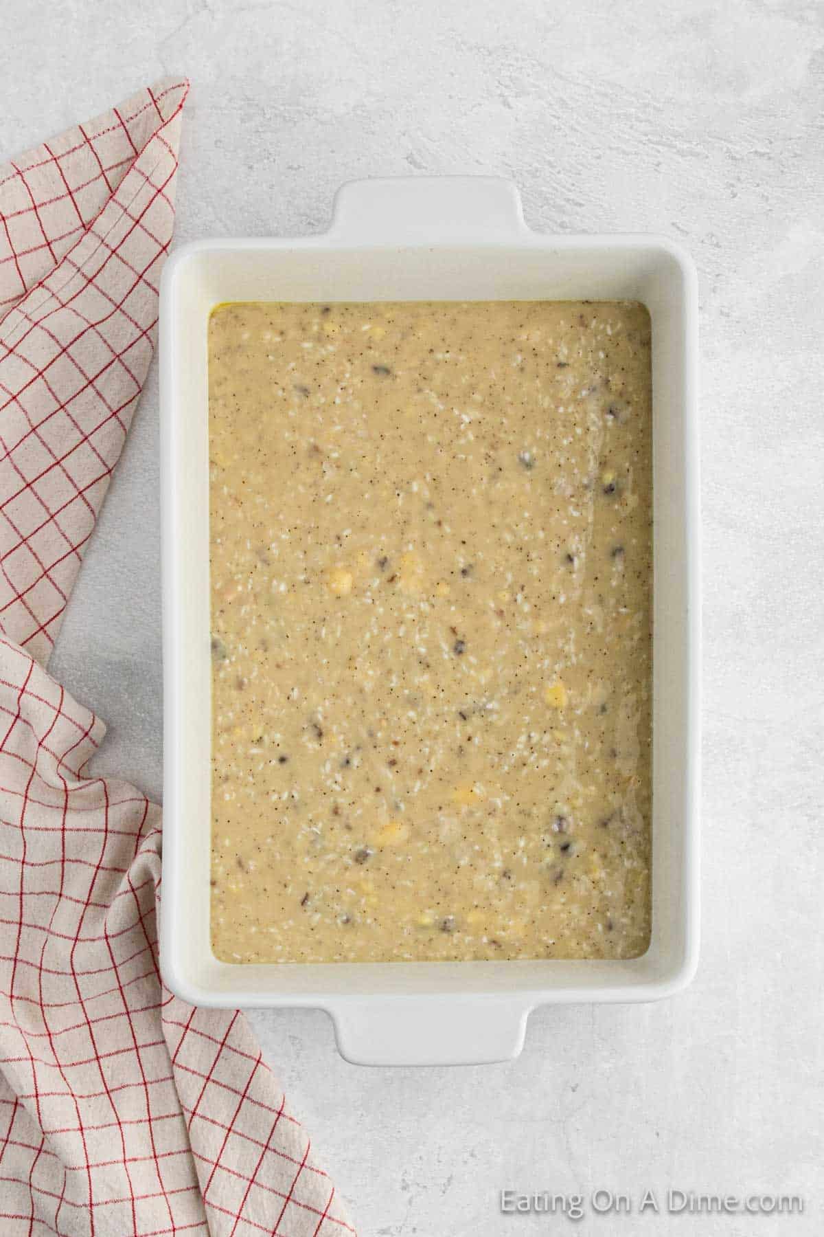 The rice mixture poured into the white casserole dish