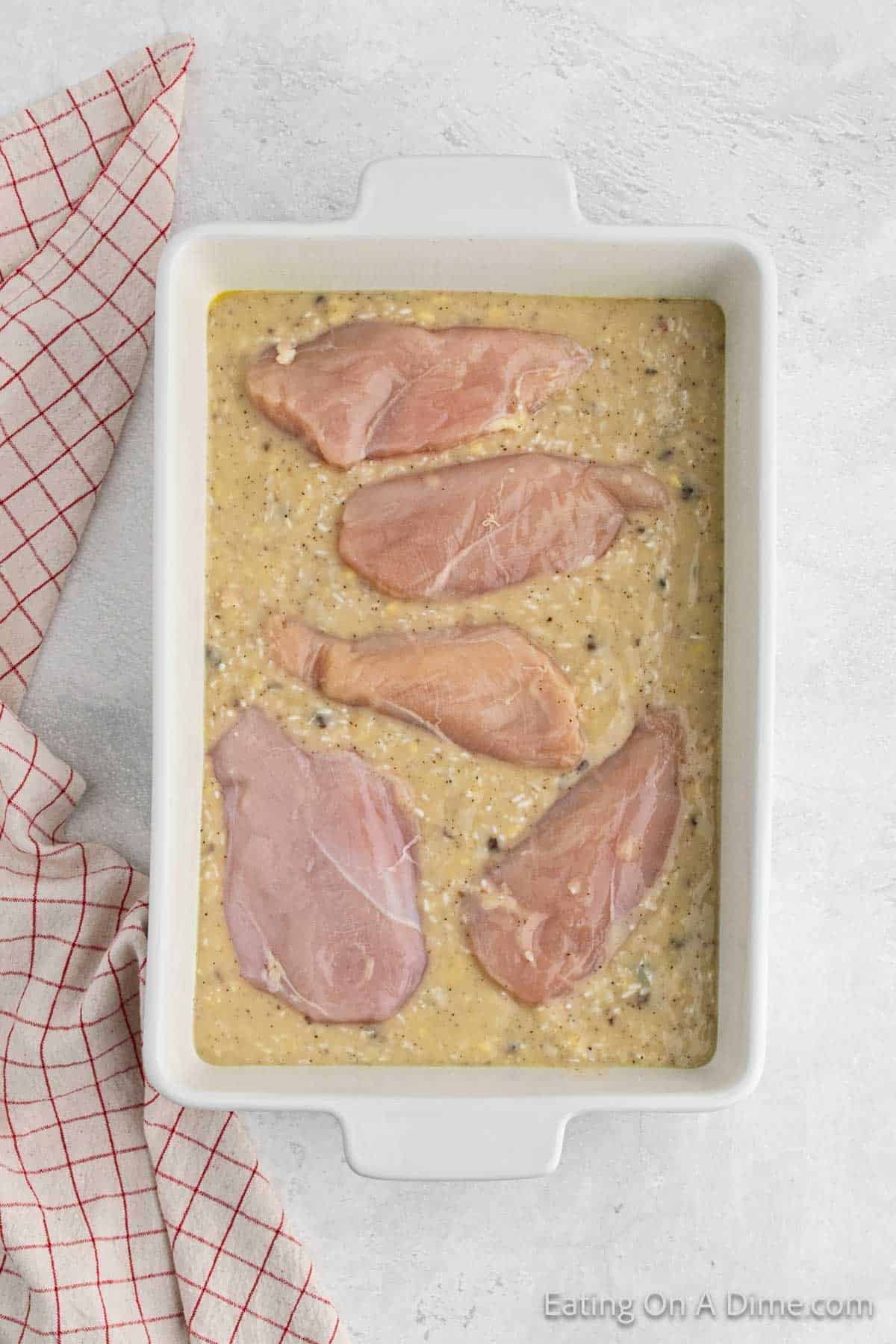 Chicken breast placed in the casserole dish with the rice mixture