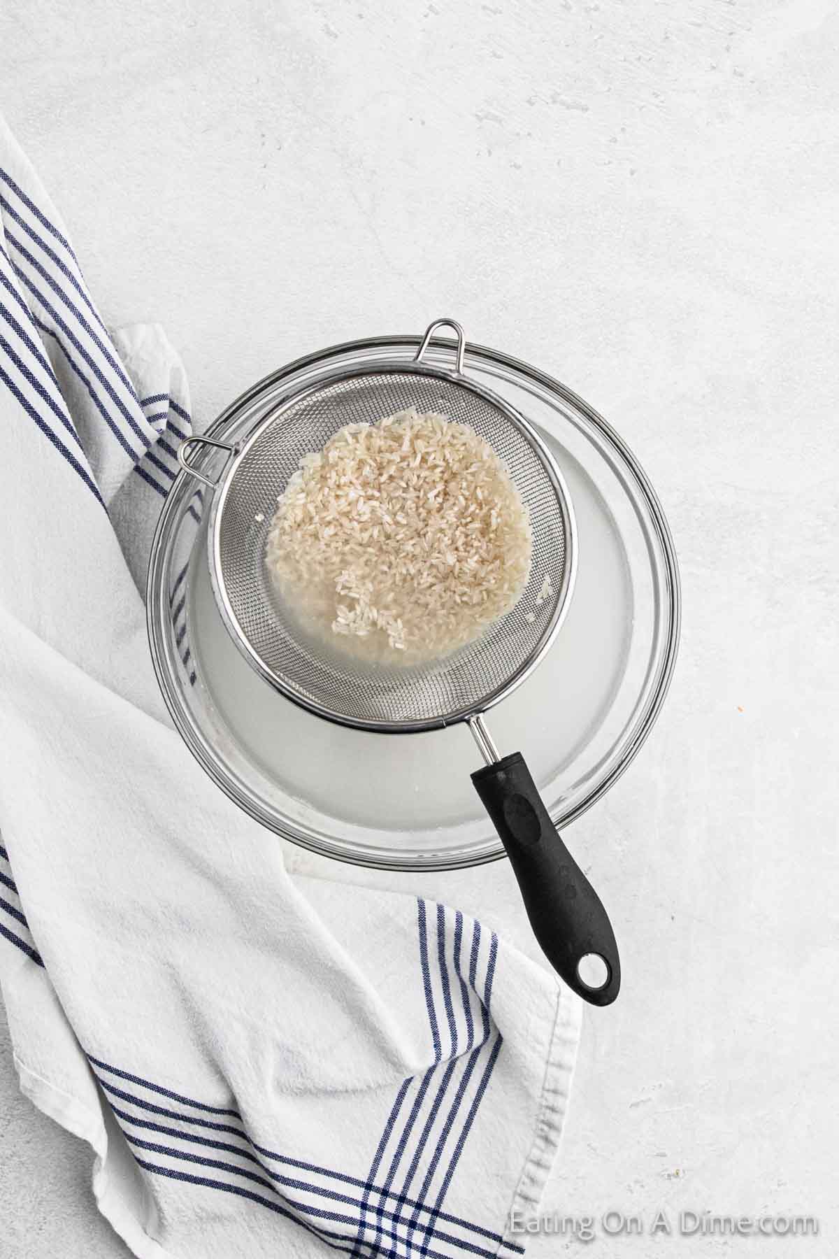 Rinsing rice in a strainer over a bowl