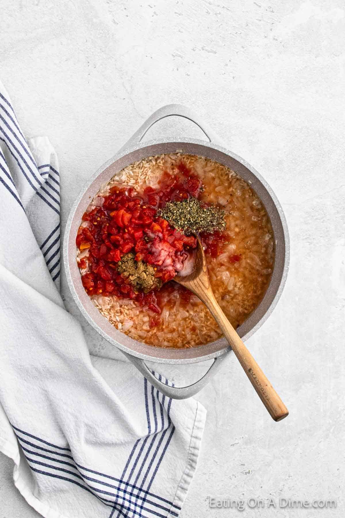 Adding the diced tomatoes and seasoning with the rice mixture