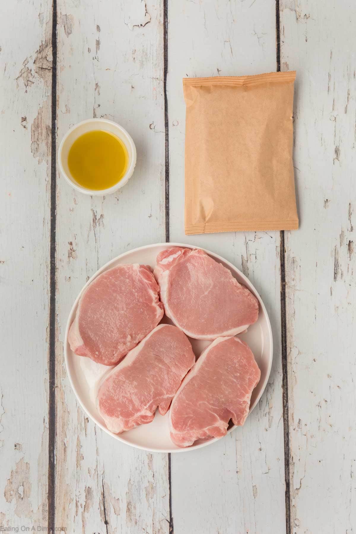 A bowl of oil, place of boneless pork chops and a packet of shake and bake seasoning