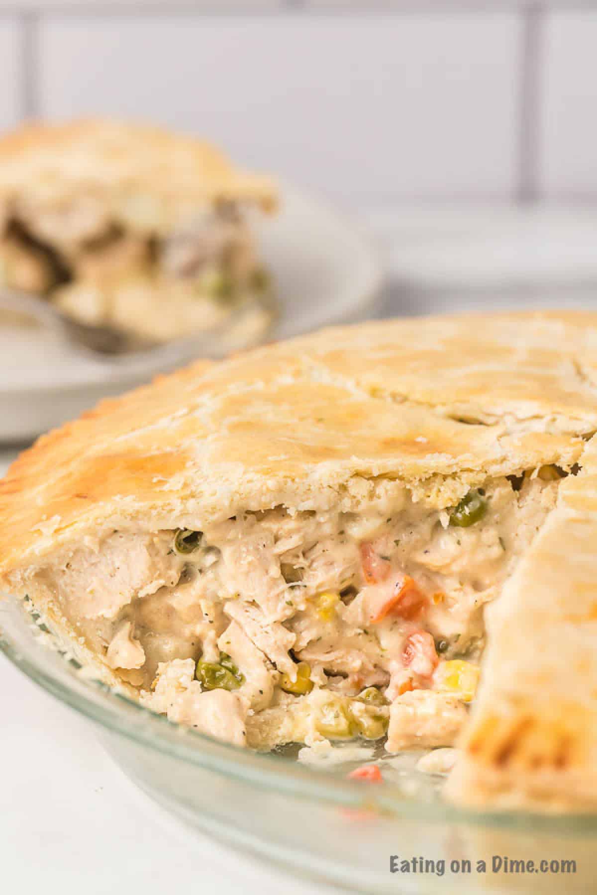 Double crust chicken pot pie in a pie plate with a slice missing