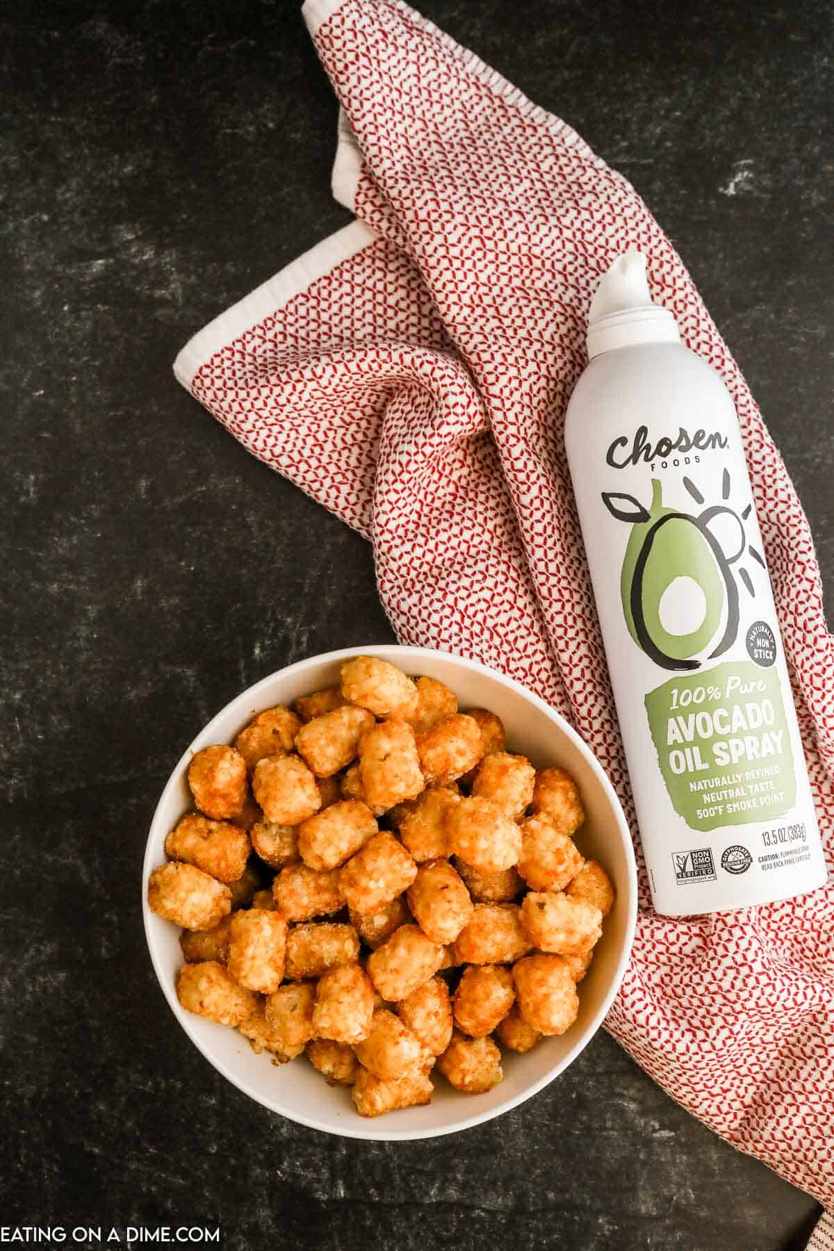 Tator Tots in a bowl with avocado spray on the side