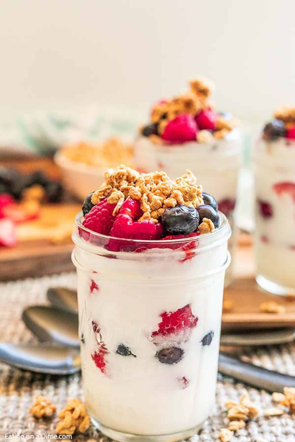 Fruit and Yogurt Parfait in a mason jar topped with granola, raspberries and blueberries