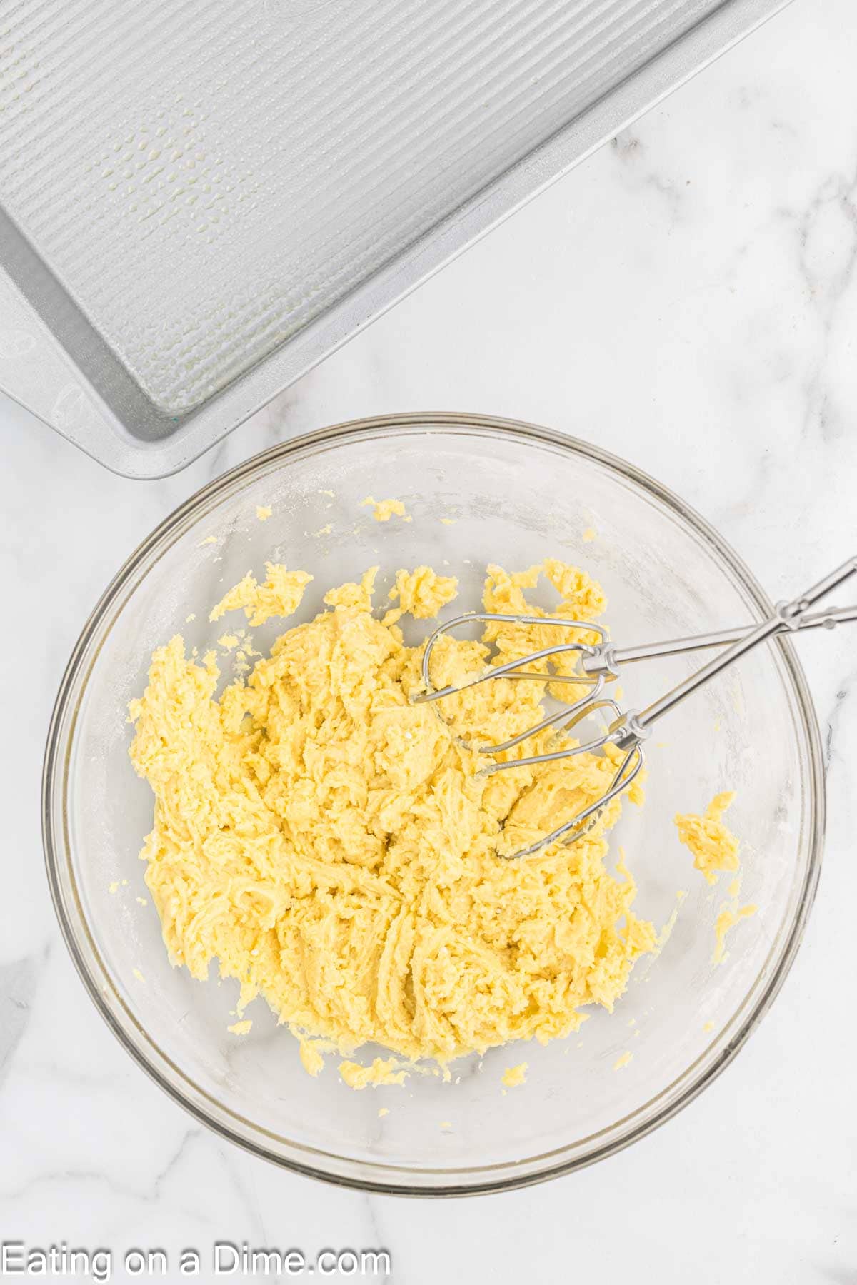 Cake mix blended with butter and egg in a bowl with a hand mixer