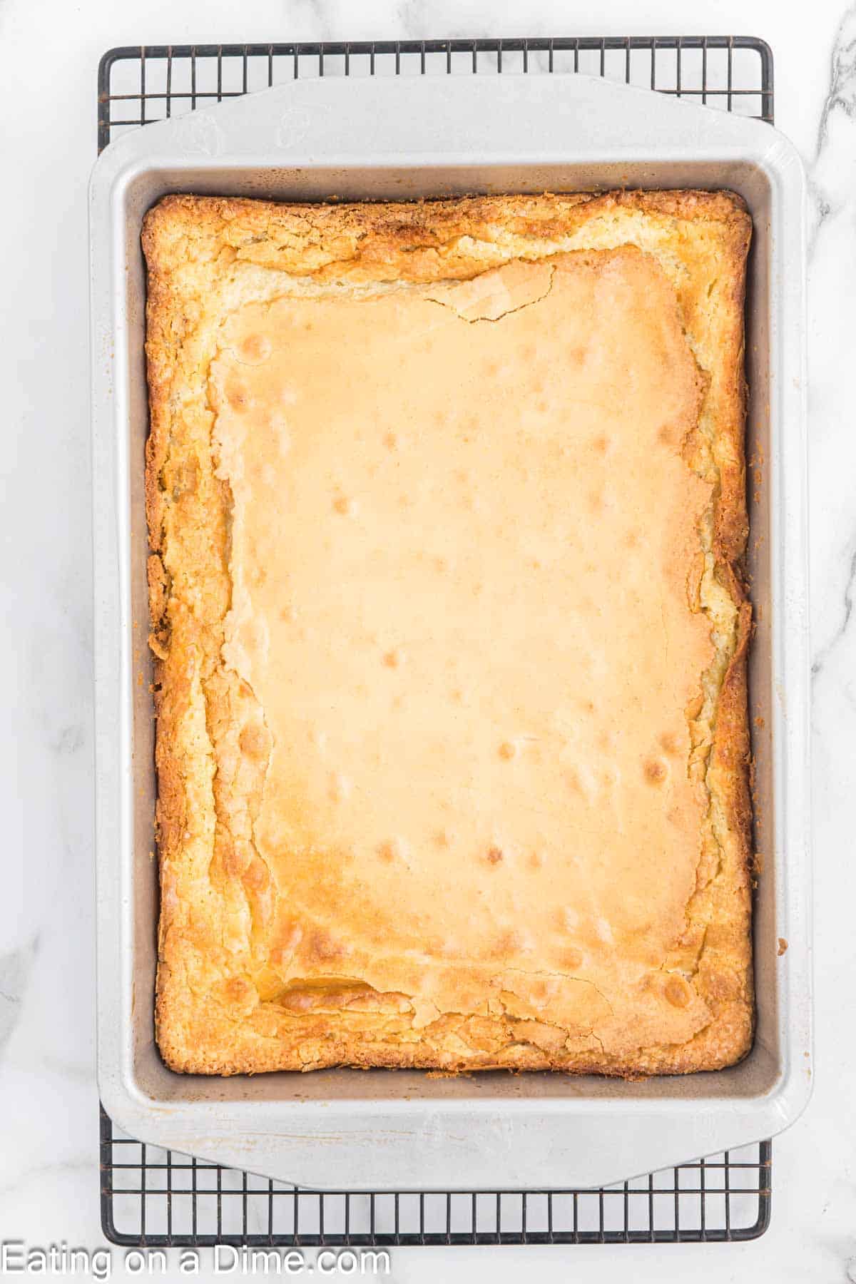 Baked butter cake in a cake pan on a wire rack