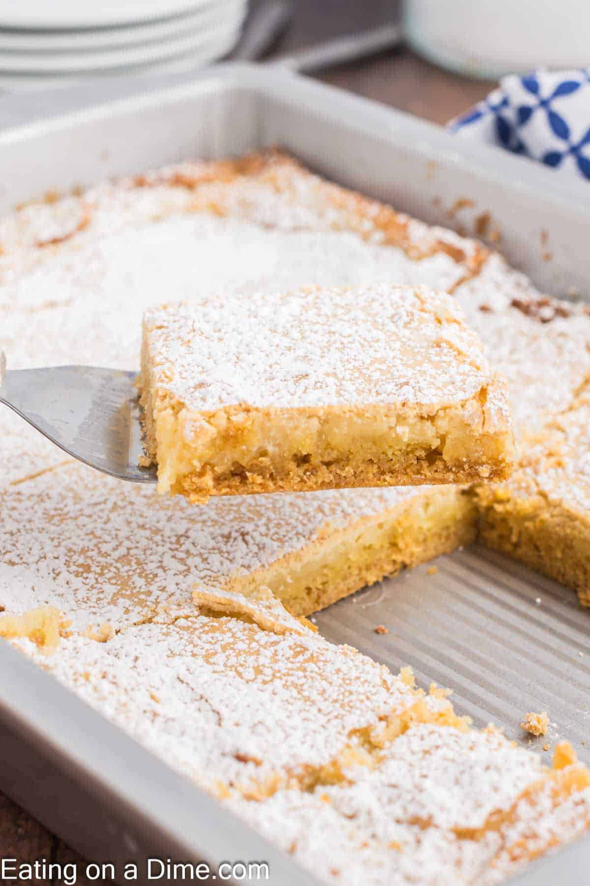 Butter cake in a baking dish with a serving on a spatula