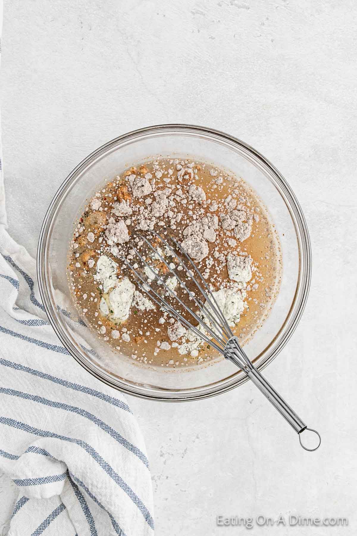 Combining the seasoning mix with the broth and water in a bowl