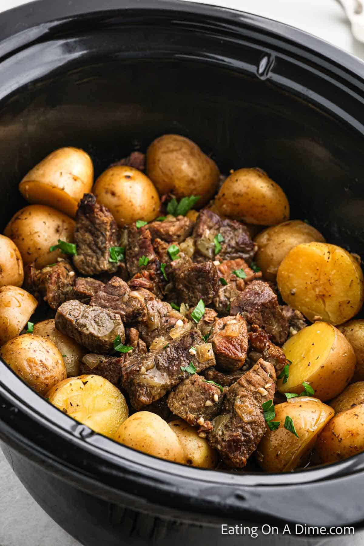 Cooked steak bites with cooked yellow gold potatoes in the slow cooker