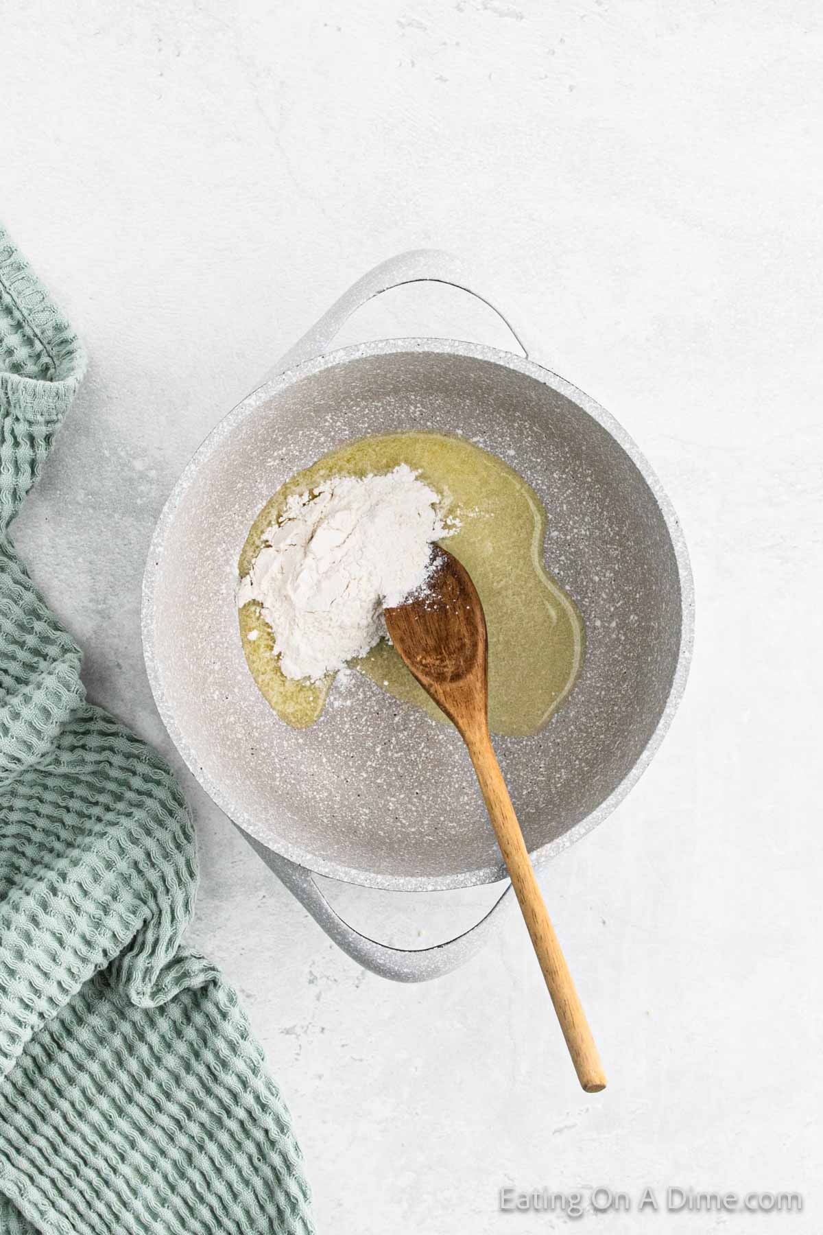 Melted butter in a large pot with flour and a wooden spoon