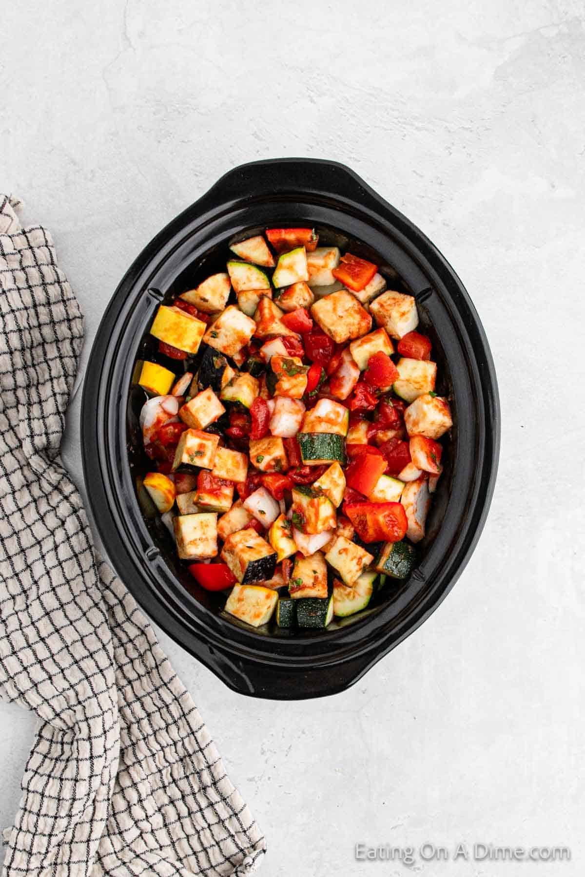 Tomato based sauce mixed with chopped vegetables in the slow cooker