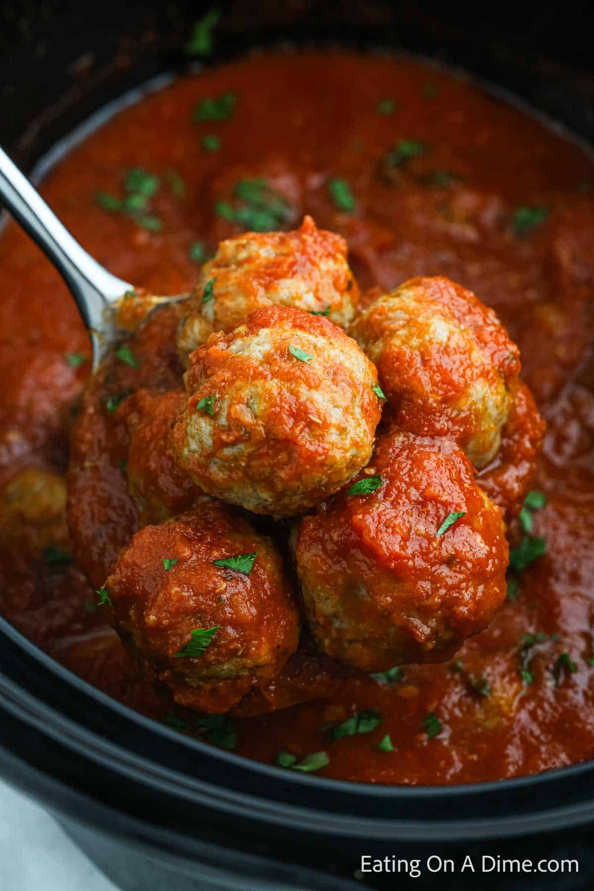 Turkey Meatballs with sauce on a spoon serving from the slow cooker