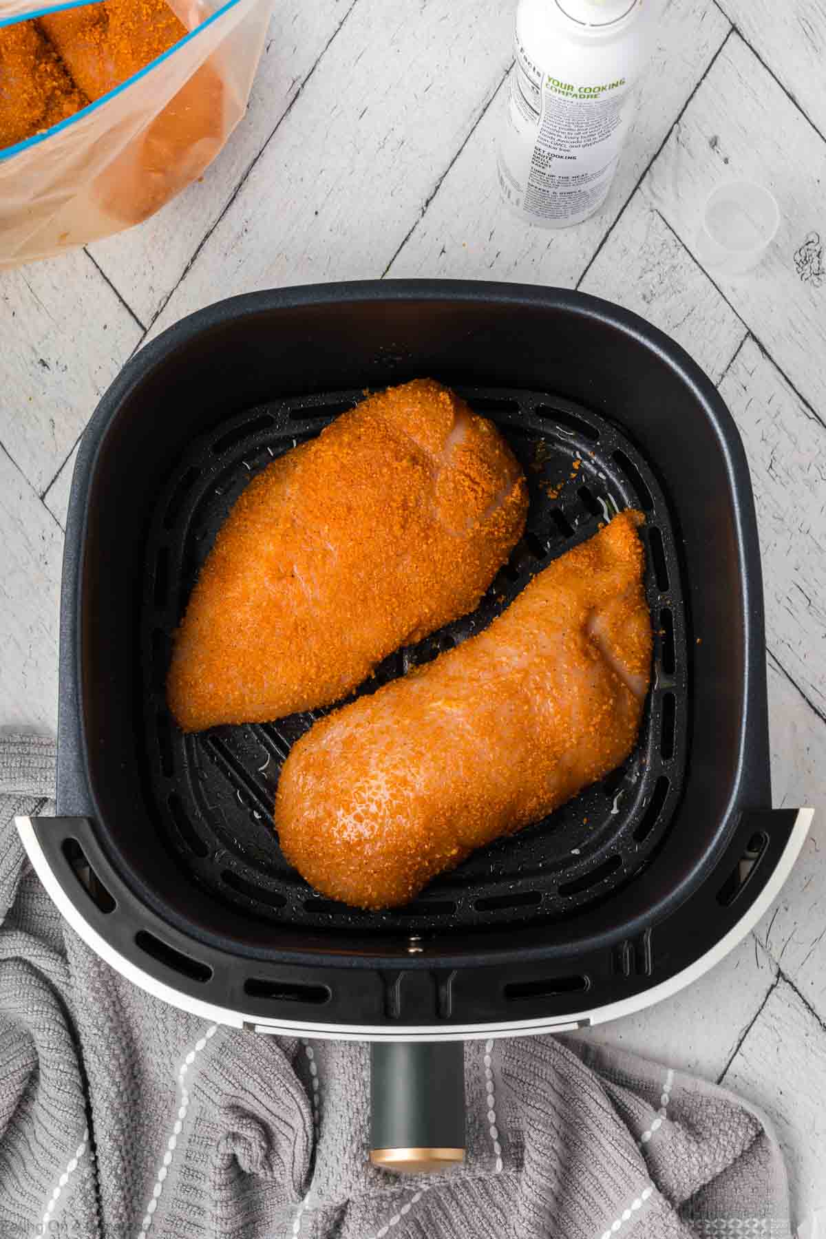 Placing coated chicken in the air fryer basket