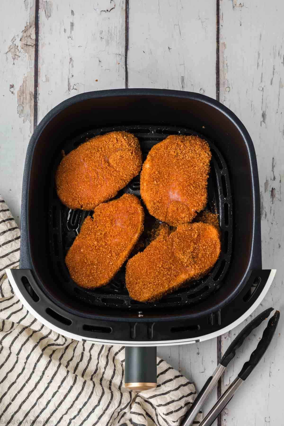 Seasoned pork chops in the air fryer basket