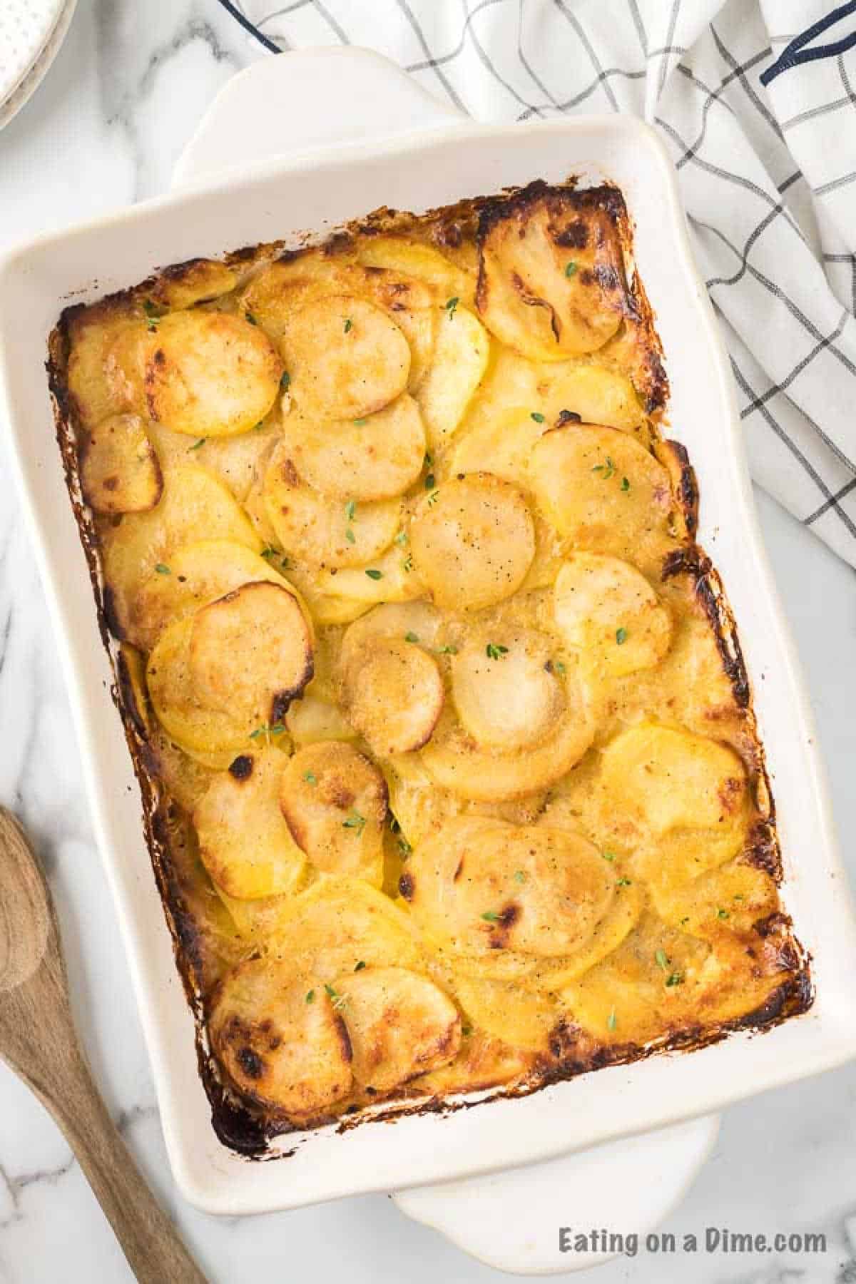 Cheesy Scalloped Potatoes baked golden brown and ready to serve in a casserole dish