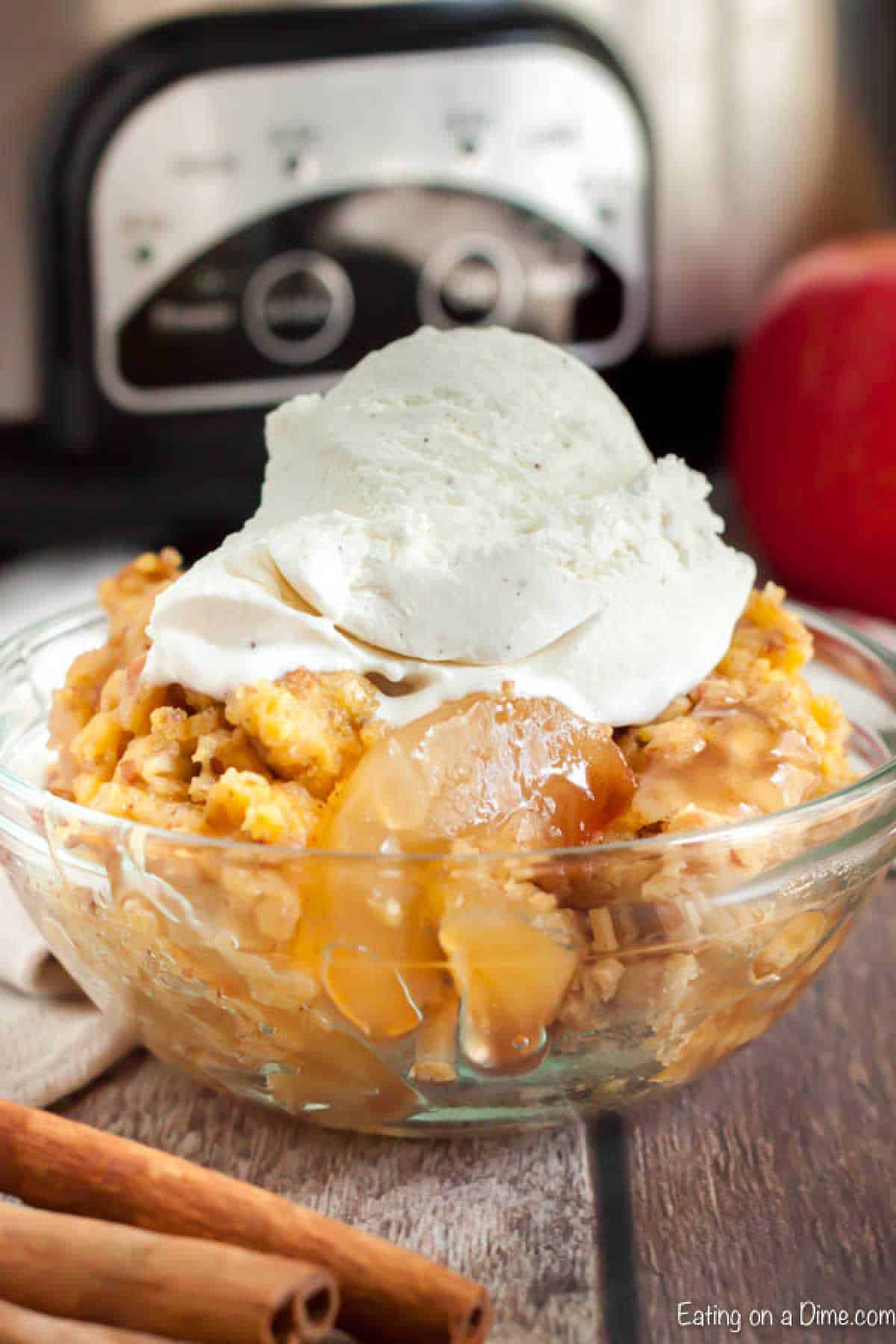 Apple dump cake with vanilla ice cream on top in a bowl