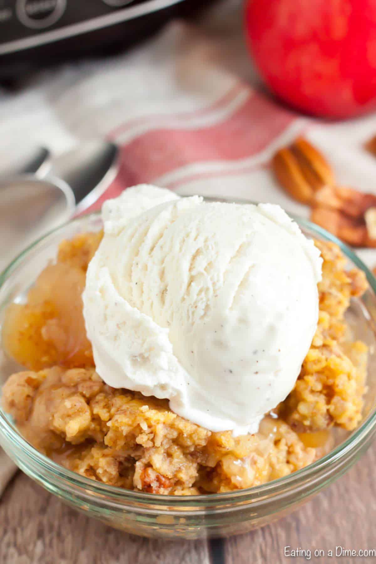 Apple dump cake with vanilla ice cream on top in a bowl