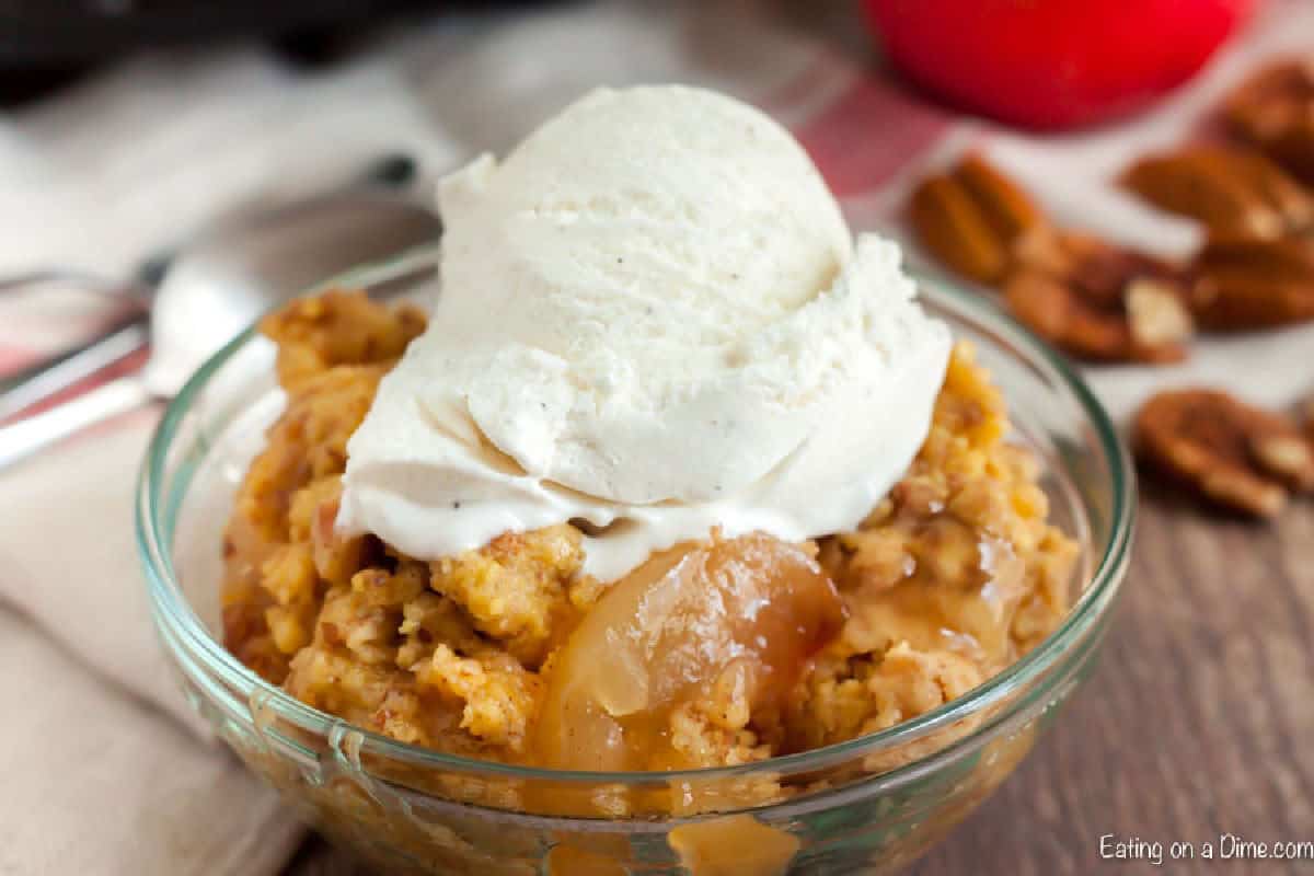 Apple dump cake with vanilla ice cream on top in a bowl