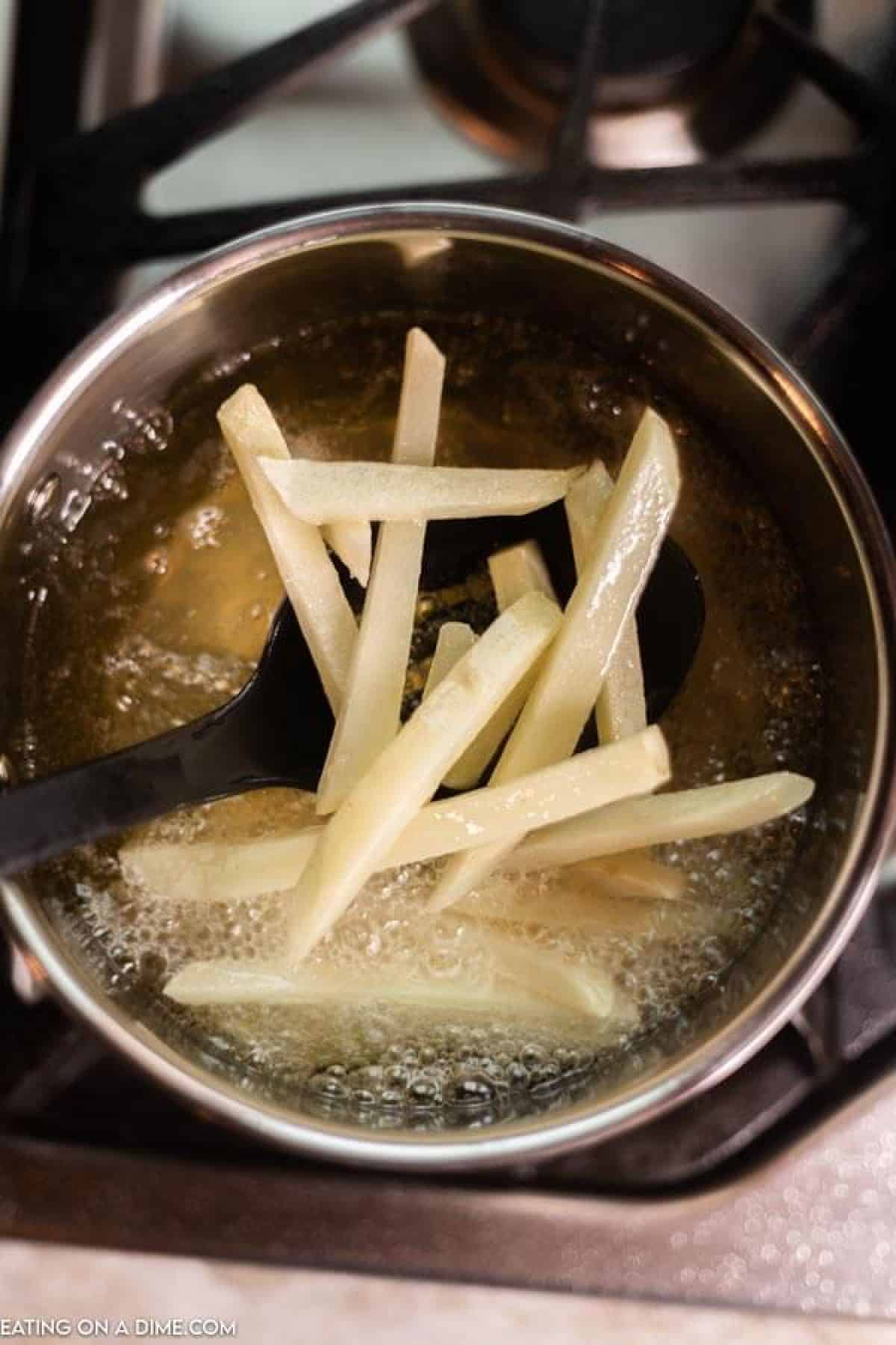 cut potatoes going into pan with hot oil