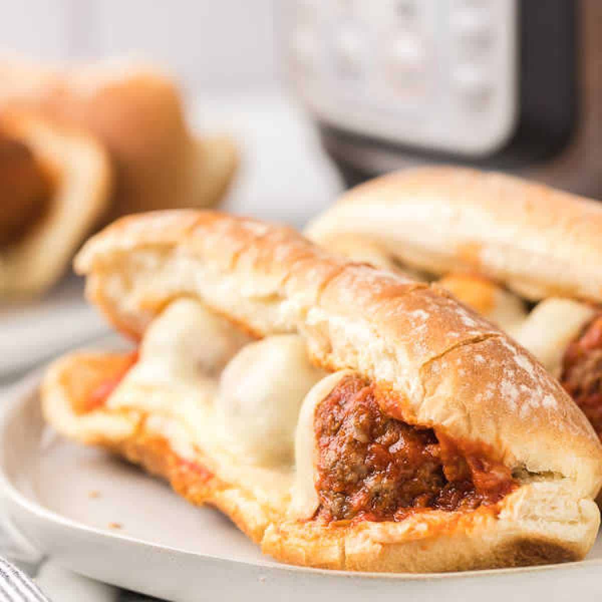 Meatball subs topped with melted cheese on a plate