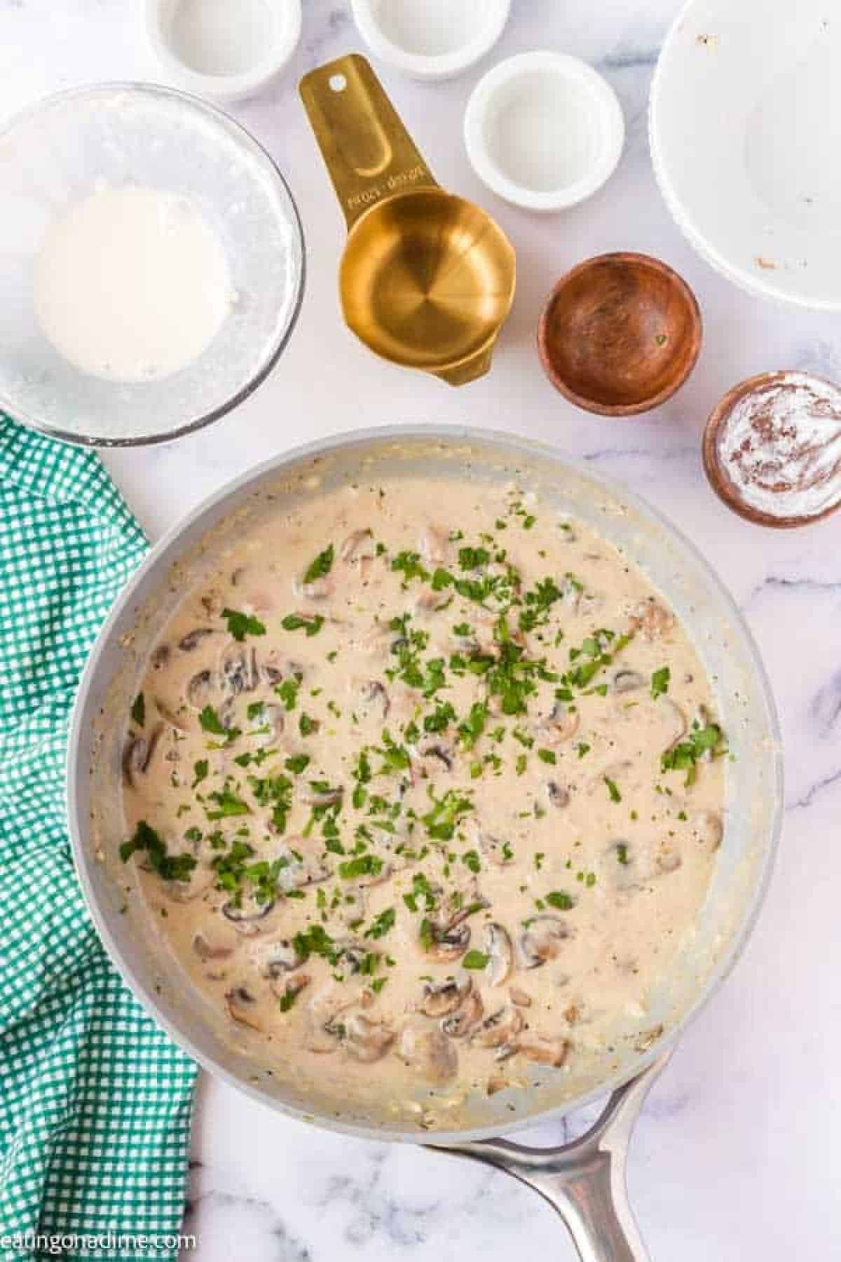 Creamy mushroom sauce in a skillet topped with fresh parsley