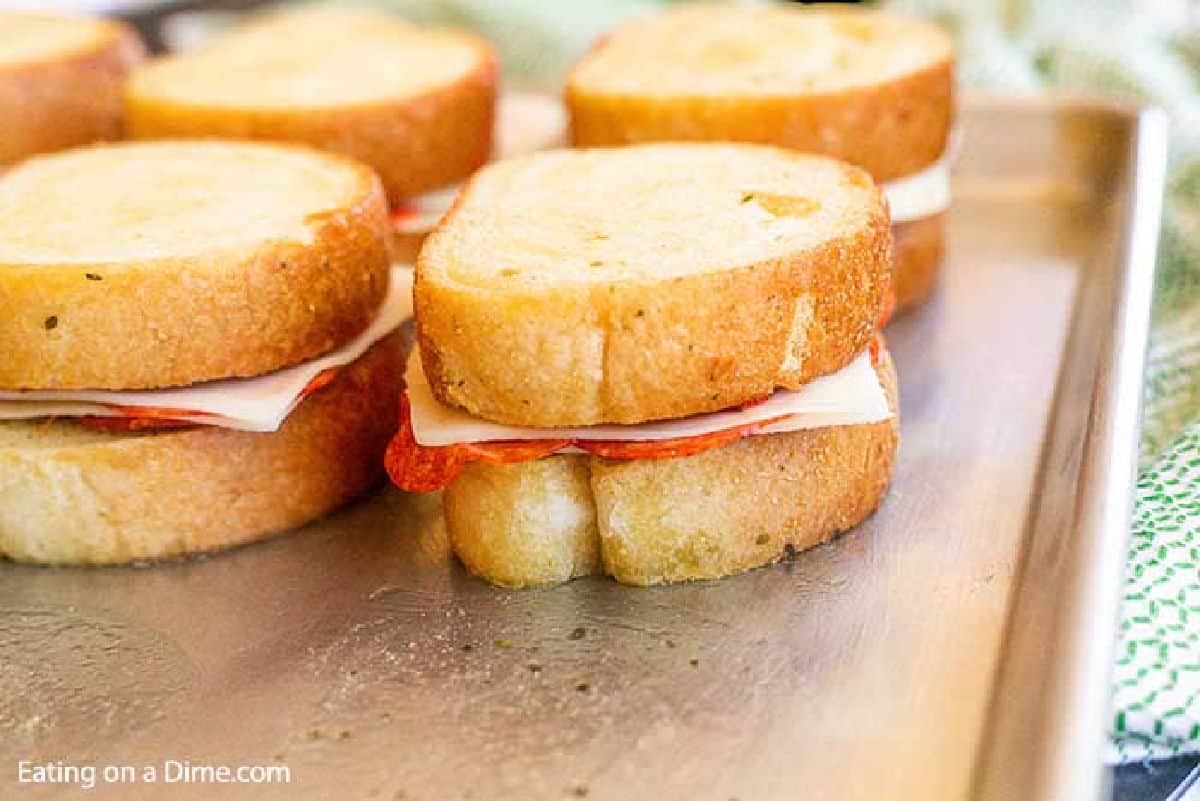 Topping the bread on the slice cheese on a baking sheet