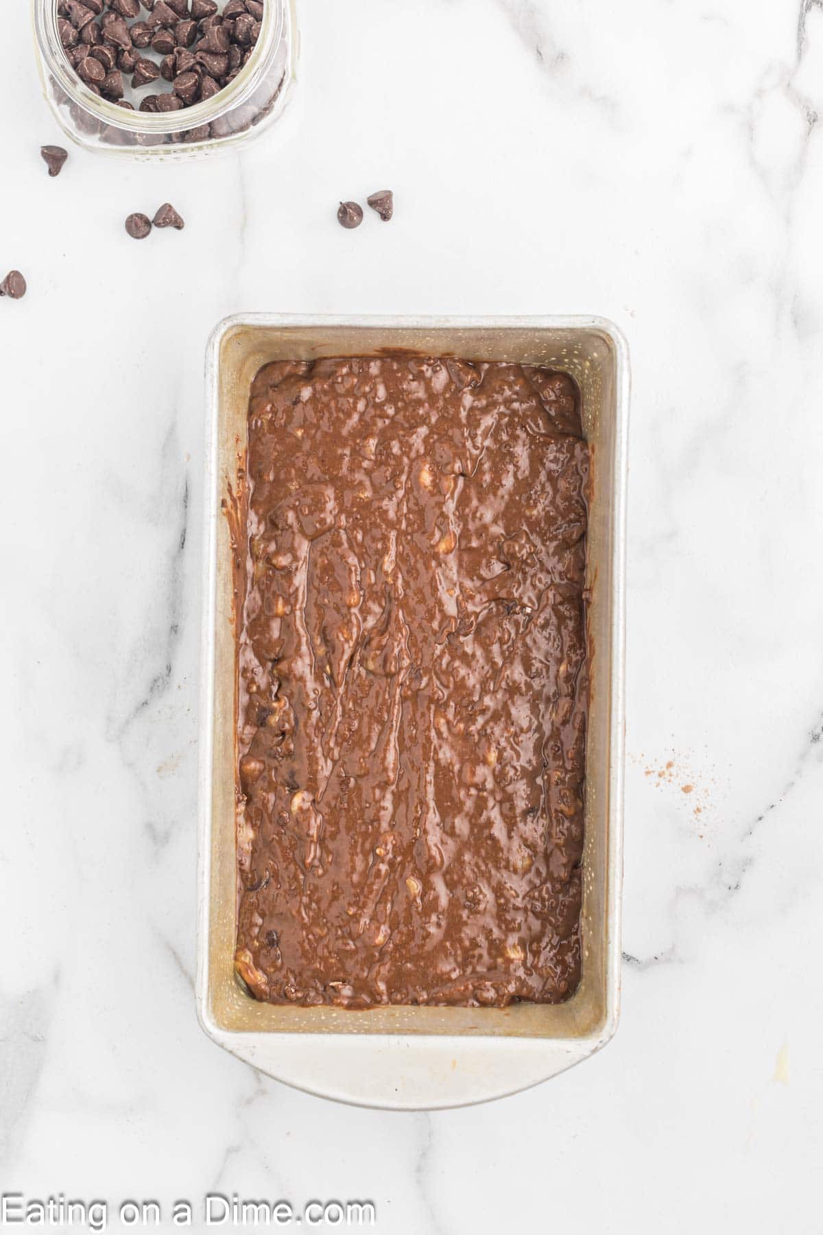 Pouring the chocolate banana bread into a loaf pan