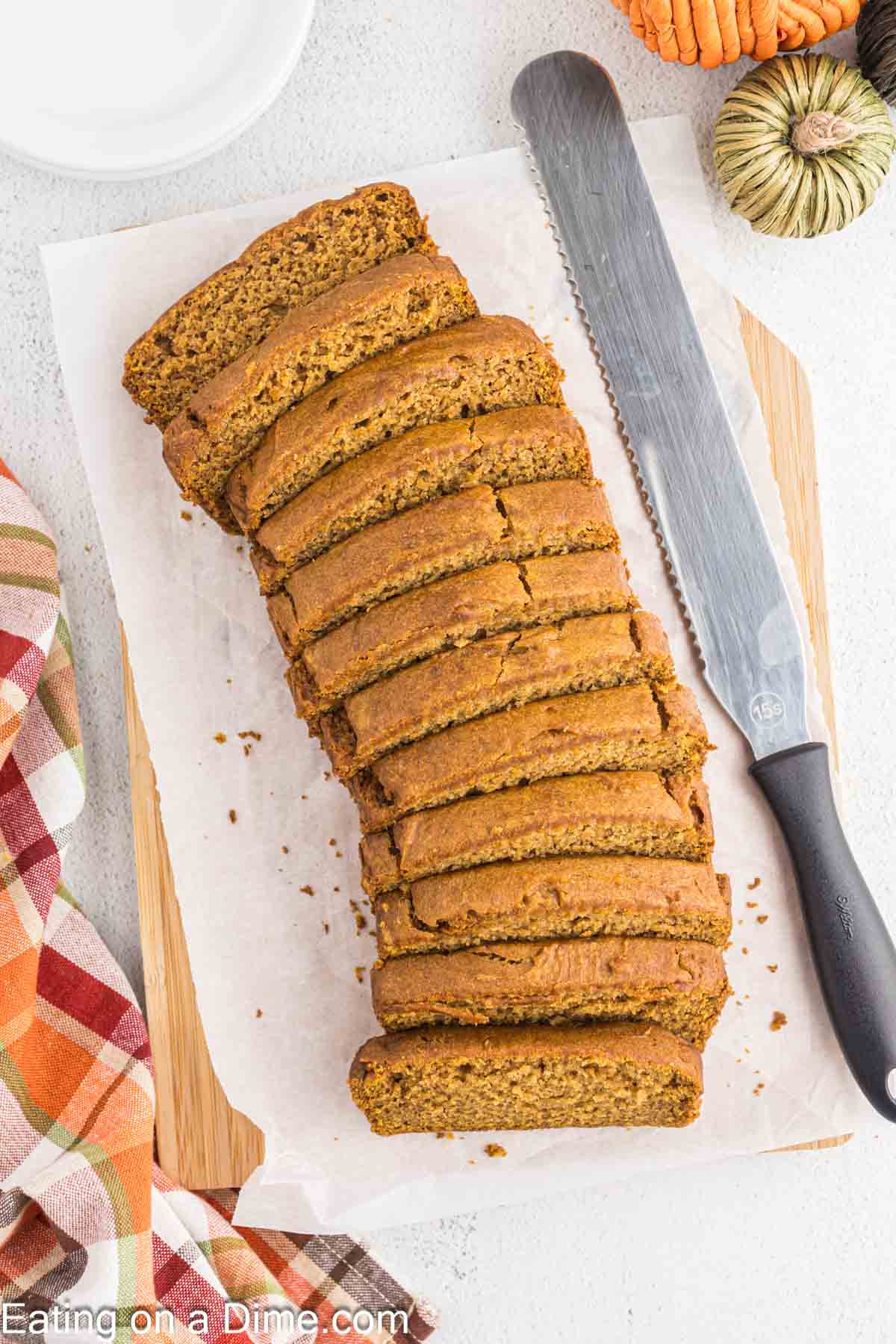 Slice pumpkin bread on a cutting board lined with parchment paper