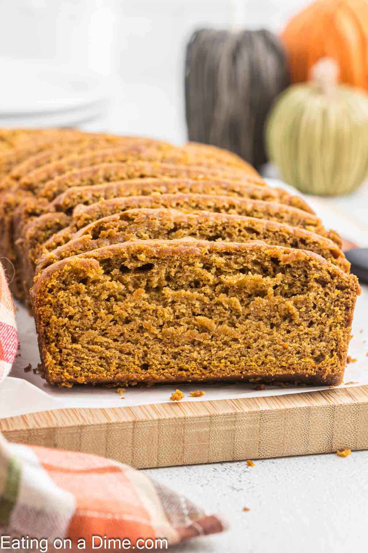 Slice pumpkin broad on a cutting board with parchment paper