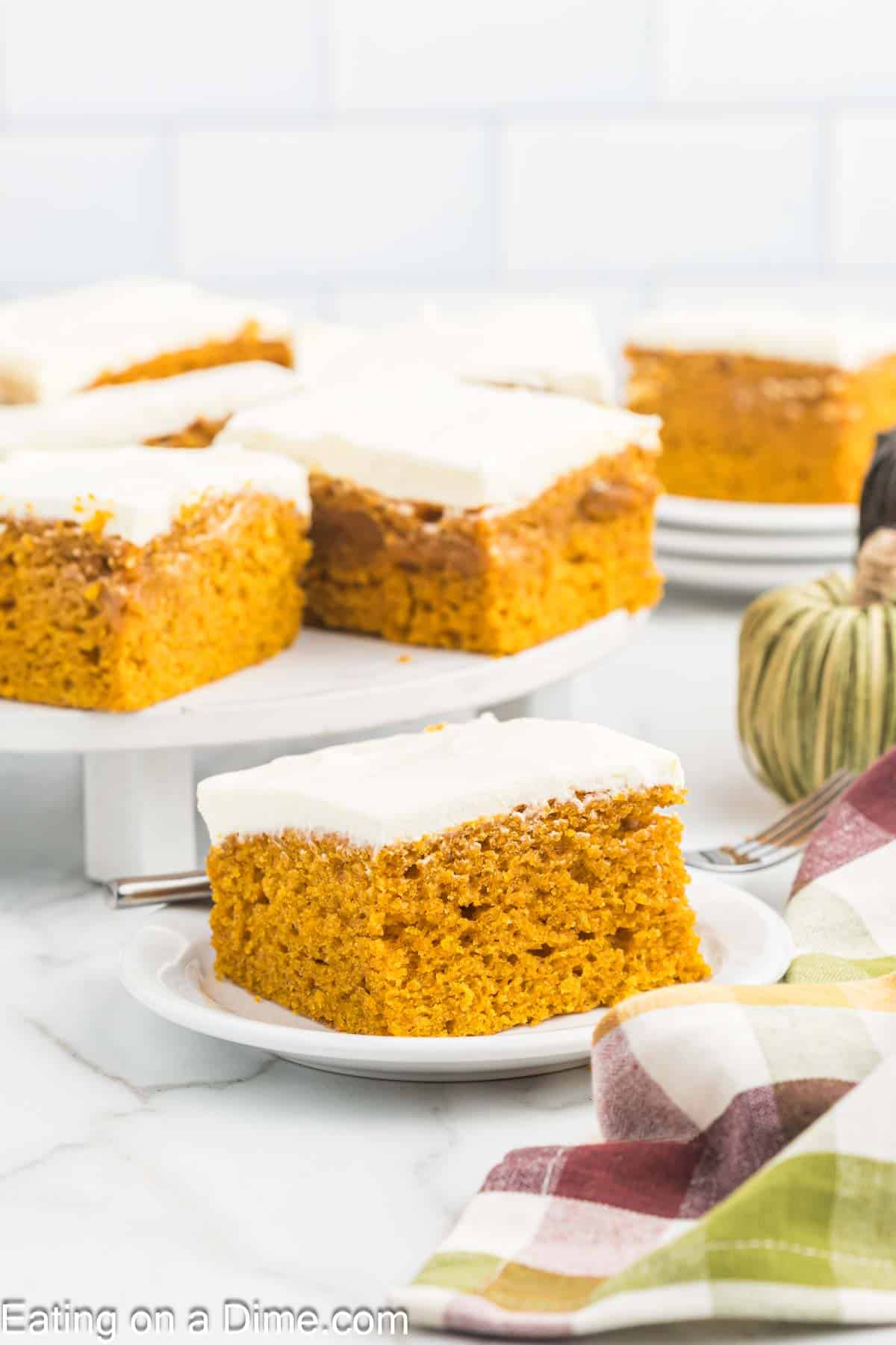 Pumpkin bars topped with cream cheese frosting on a cake pan