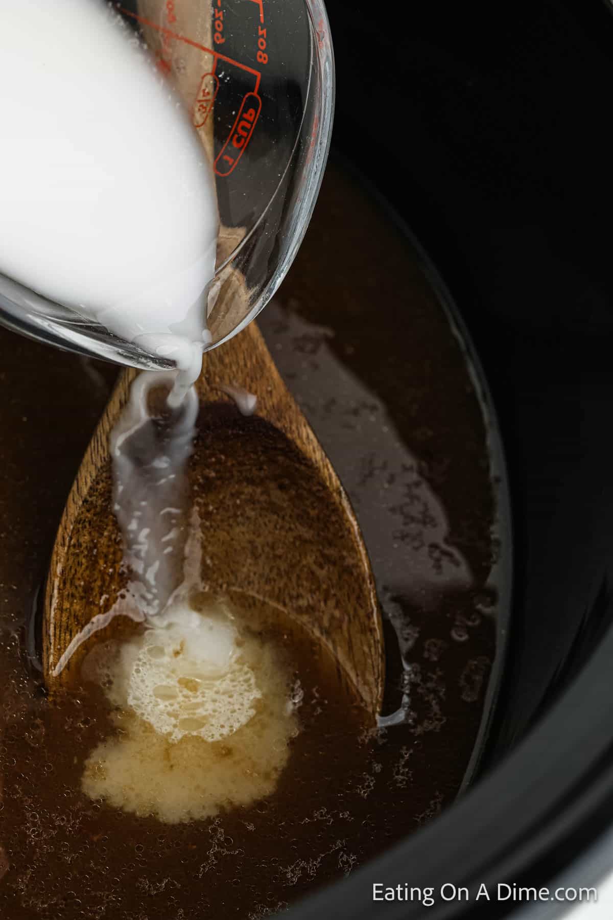 Pouring cornstarch in the slow cooker with the sauce