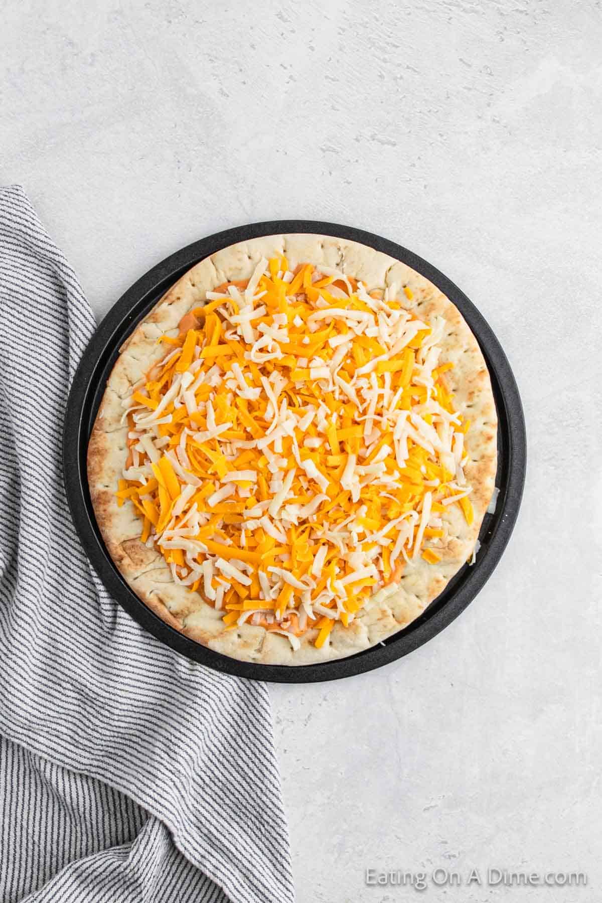 Shredded cheese topped pizza crust