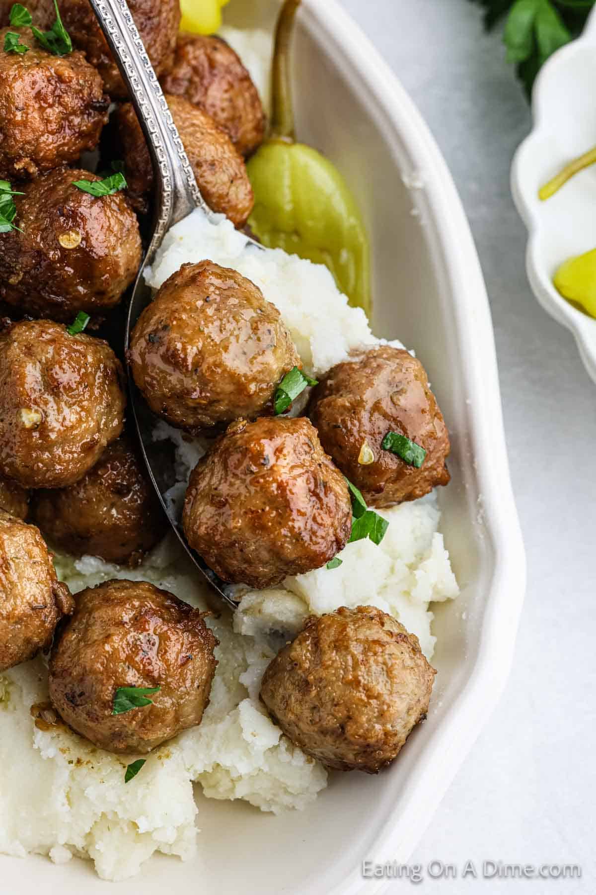 Cooked meatballs in a bowl topped with mashed potatoes