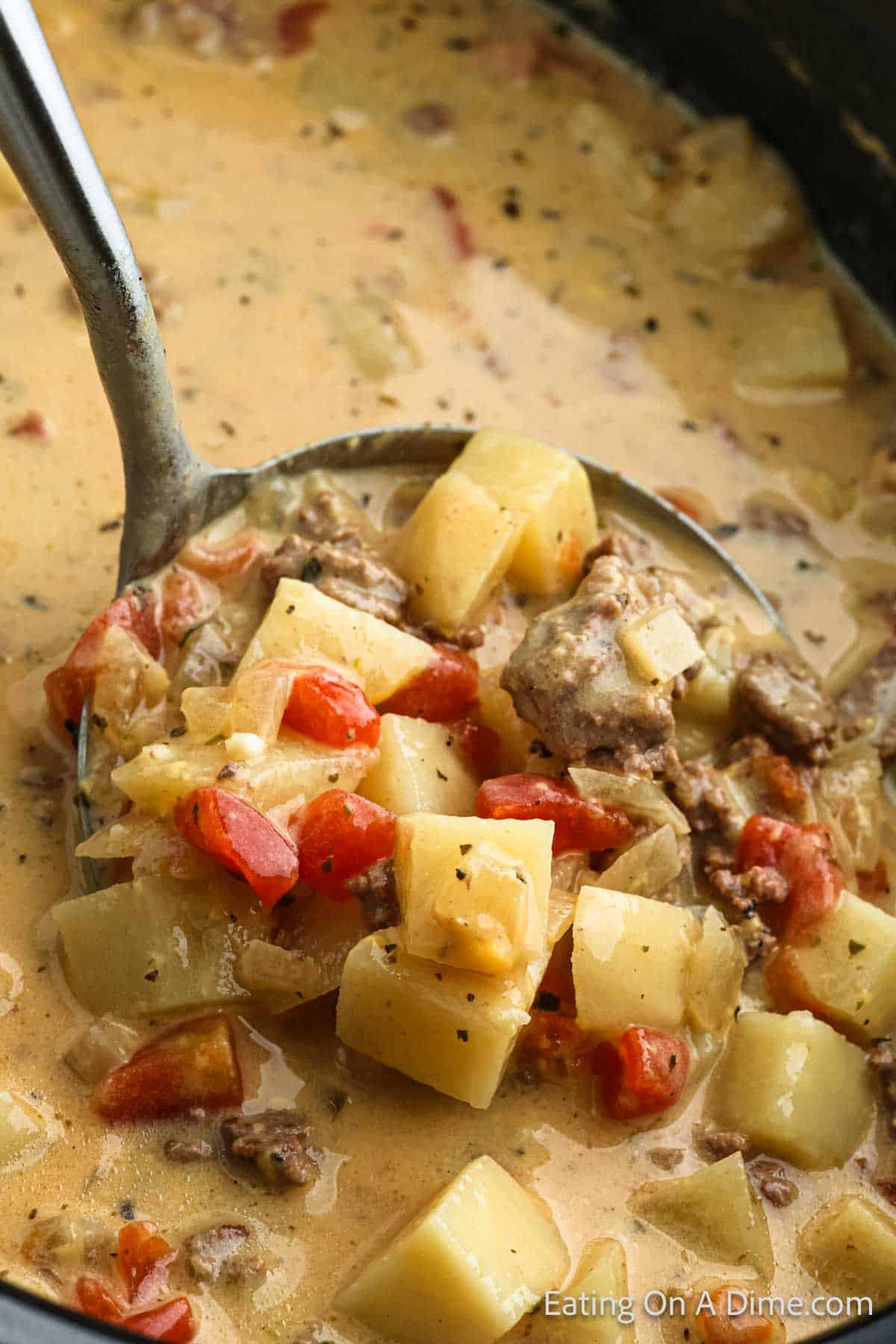 Potato and Hamburger Soup in the slow cooker with a serving on the ladle