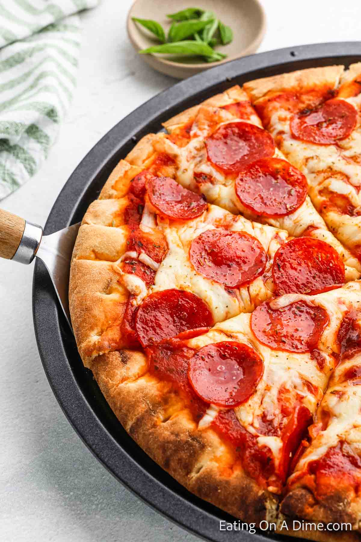 Pepperoni Pizza on a pizza pan with a spatula