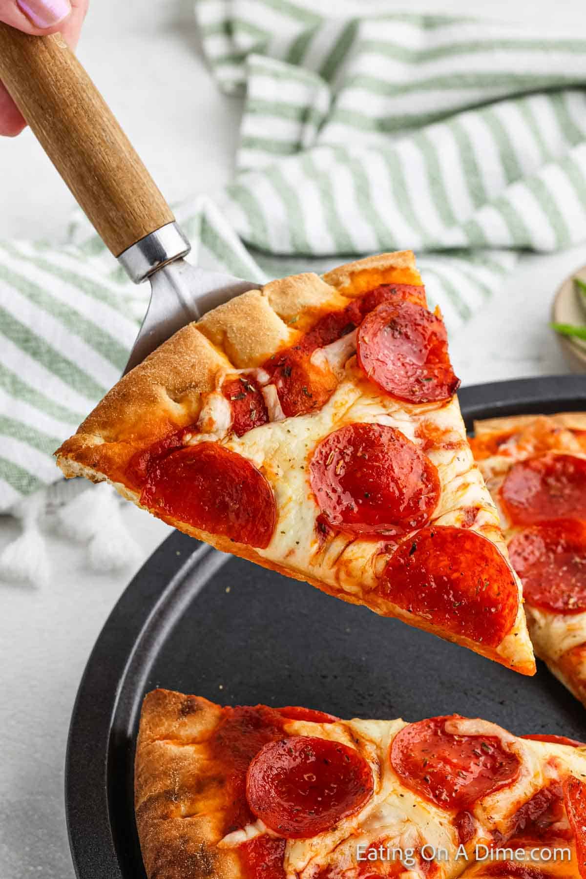 Slice of pepperoni pizza on a spatula 