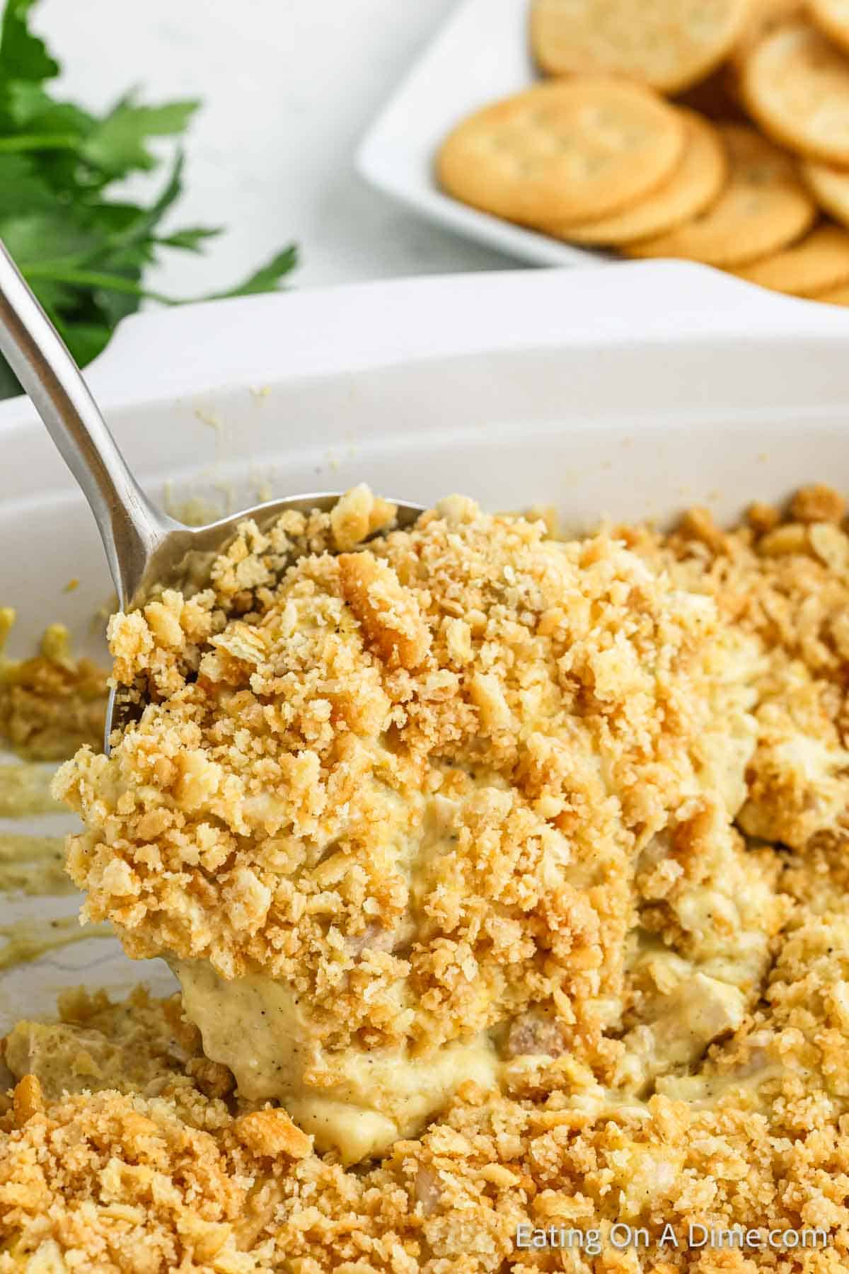 Ritz Chicken Casserole in a baking dish with a serving on a serving spoon