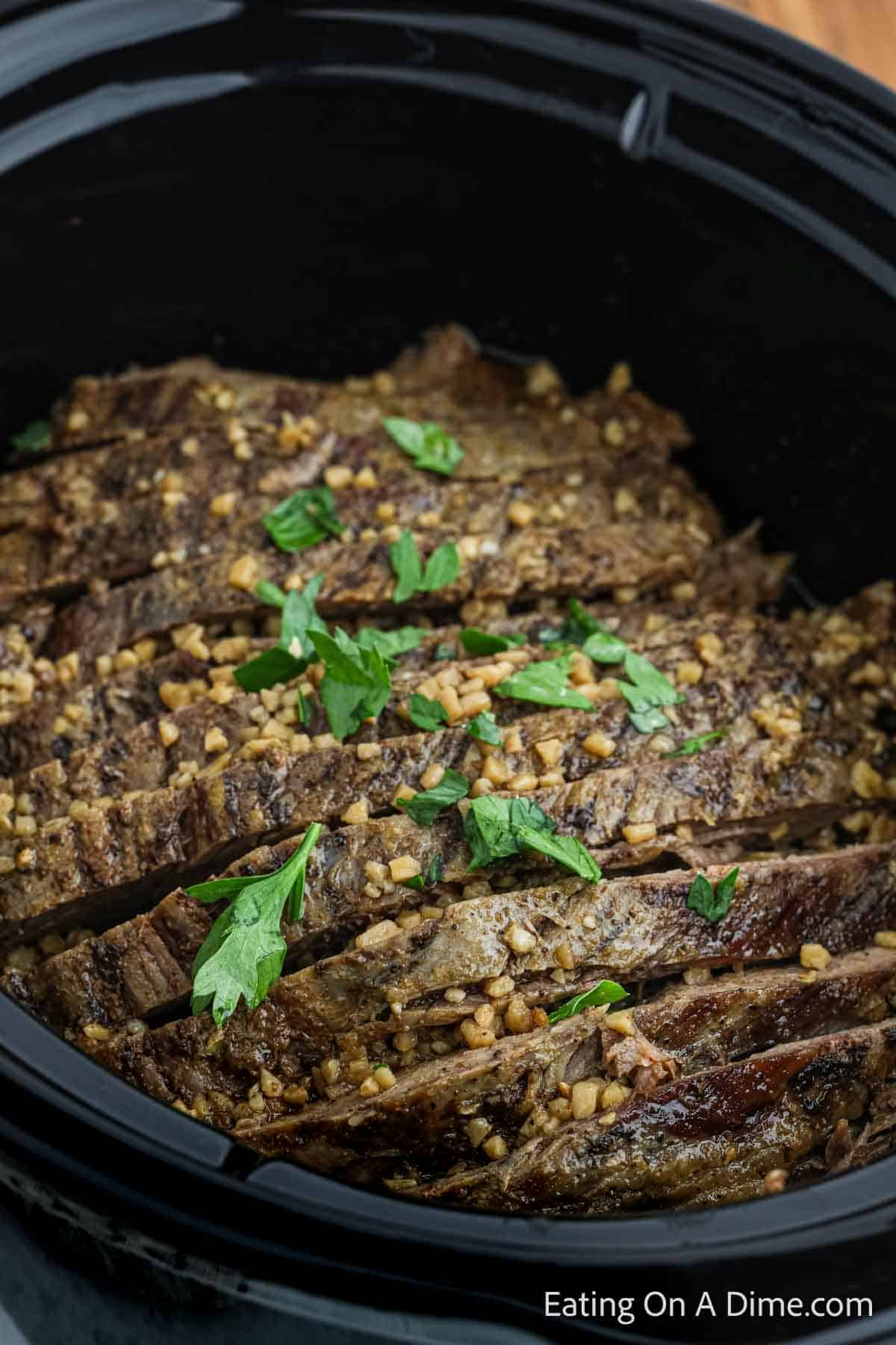 Cooked Flank Steak sliced in the slow cooker topped with fresh cilantro