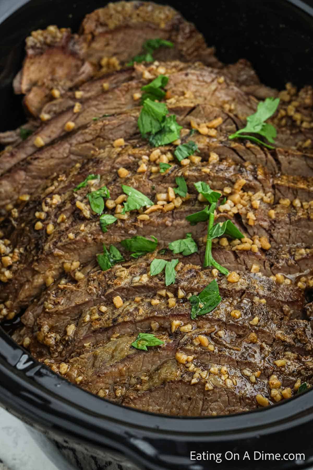 Sliced Flank steak in the slow cooker topped with cilantro