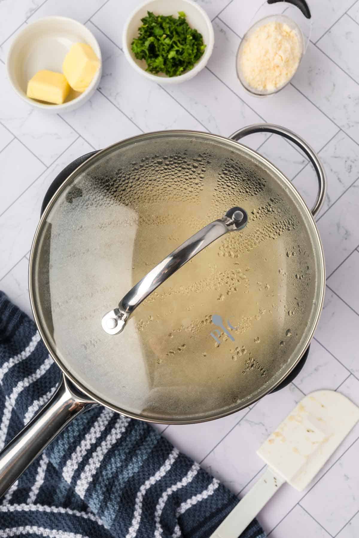 Saucepan topped with lid with small bowls of seasoning on the side