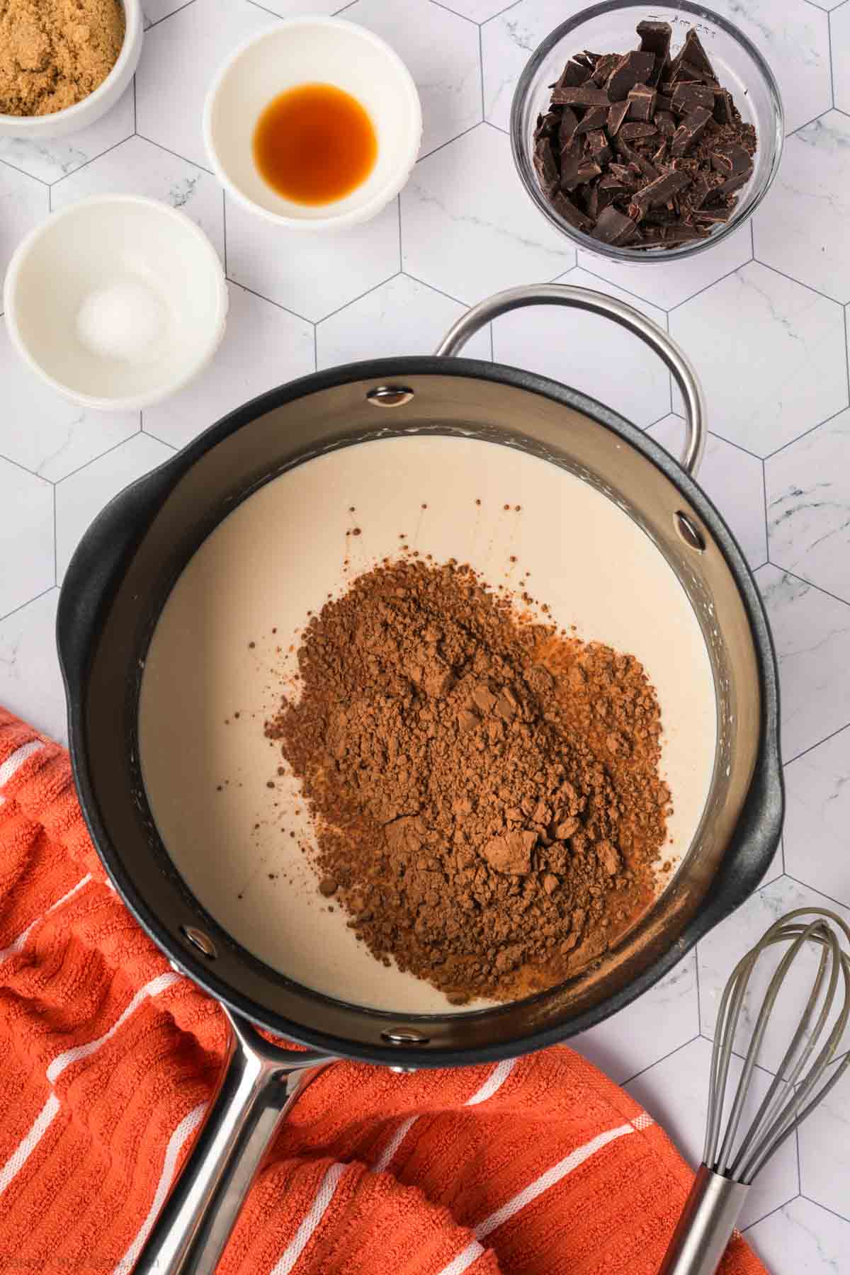 Cocoa powder to the milk mixture in a large saucepan with small bowls with dark chocolate pieces, vanilla and salt 