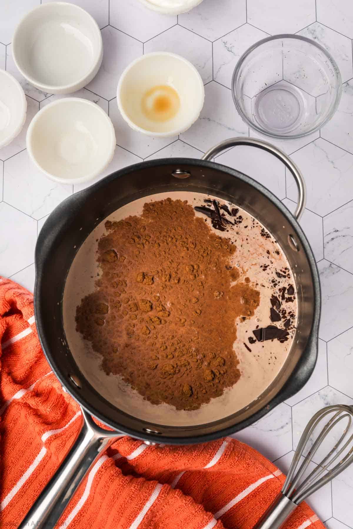 In a large saucepan mix in cocoa powder and pumpkin pie spicce, vanilla extract and chocolate pieces